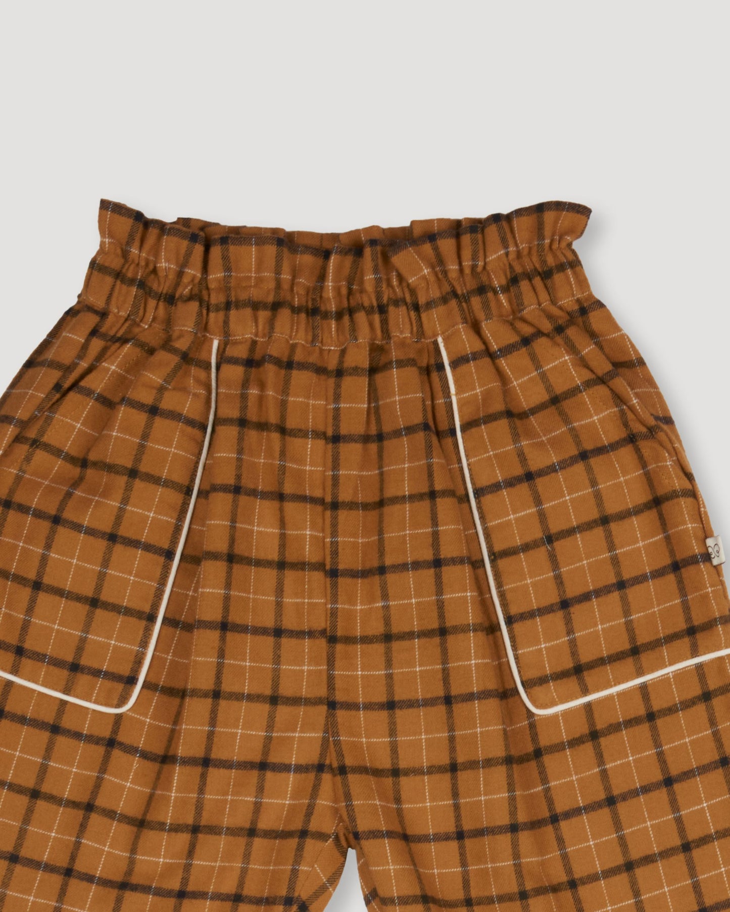 Early Sunday, Adrien Trouser in Almond Checks, made from Cotton Yarn Dyed Brushed Checks fabric, featuring Relaxed design with ample room for movement, perfect for active kids, shown in a closeup flat-lay view