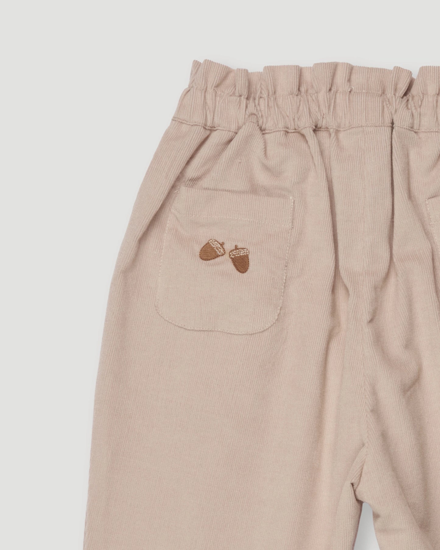 Early Sunday, Adrin Trouser in Beige, made from Cotton Corduroy fabric, featuring a relaxed silhouette with a comfortable elastic waistband, shown in a closeup flat-lay view