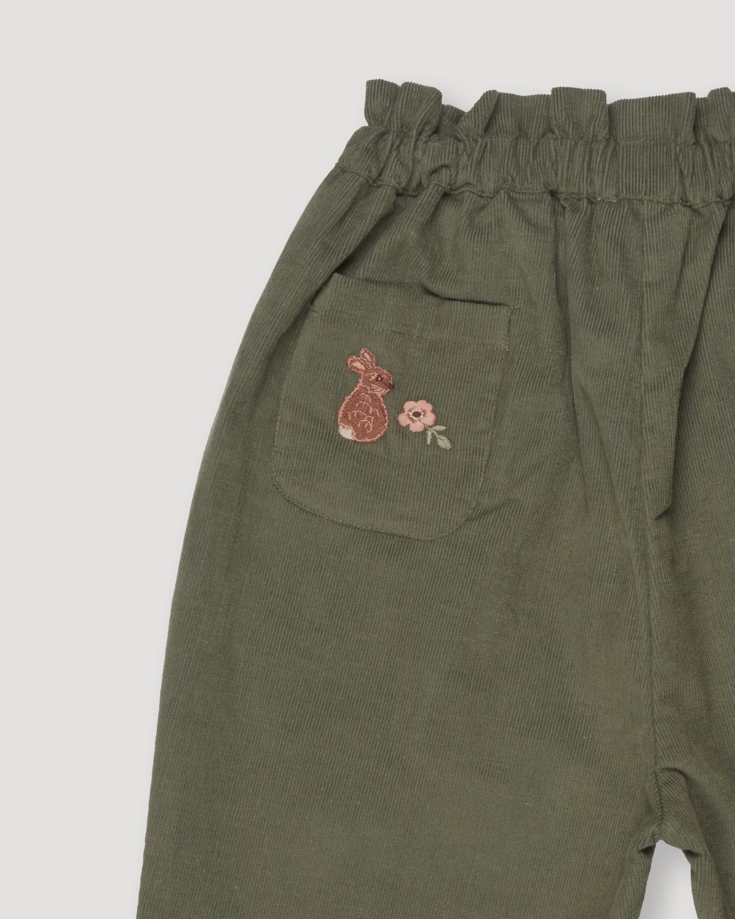 Early Sunday, Adrin Trouser in Moss, made from Cotton Corduroy fabric, featuring a relaxed silhouette with a comfortable elastic waistband, shown in a closeup flat-lay view