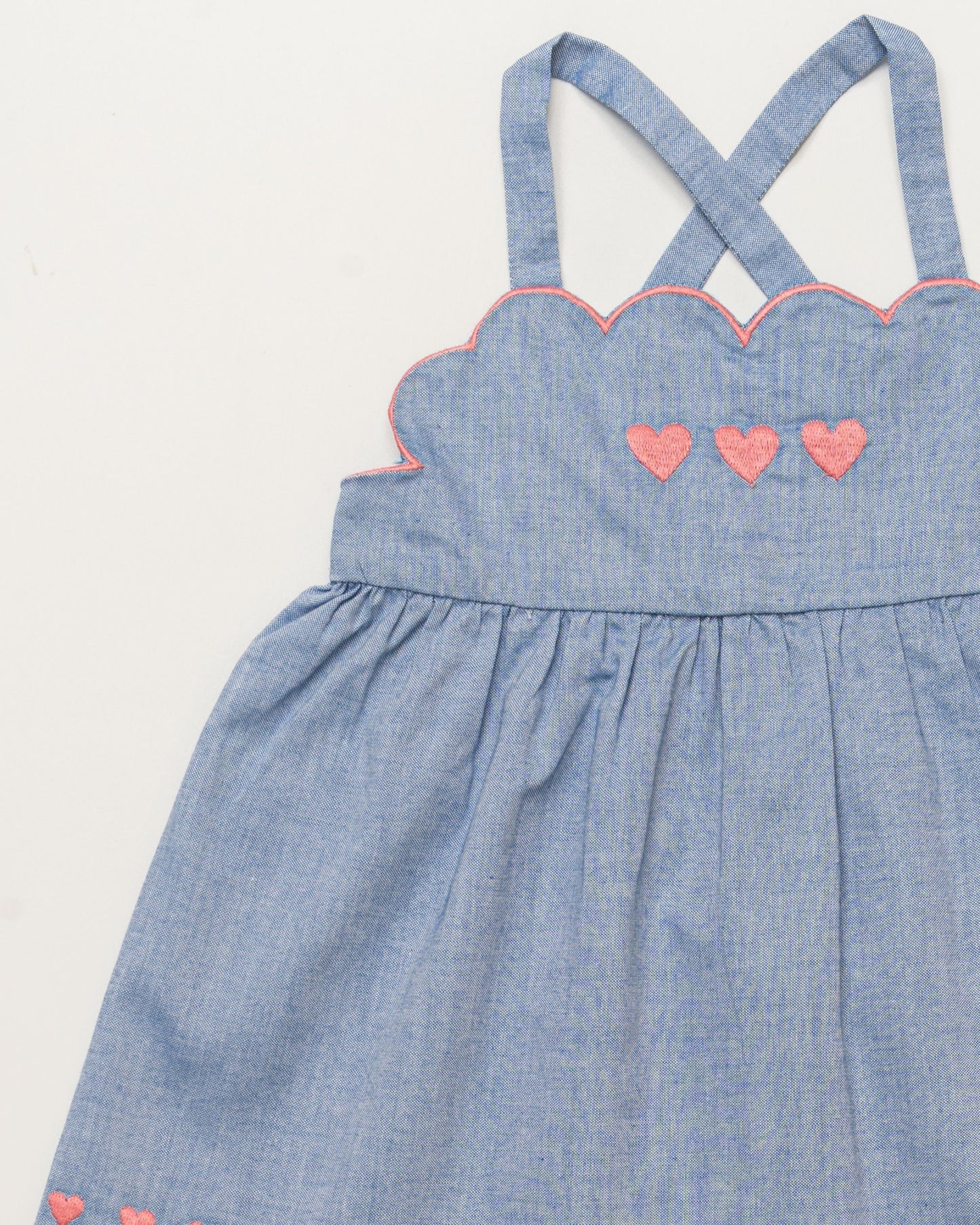 Early Sunday, Alice Baby Dress & Bloomer Set in Summer Sky color, made from 100% Cotton Chambray fabric, featuring a sleeveless design with a smocked bodice & matching bloomers, shown in a closeup flat-lay view
