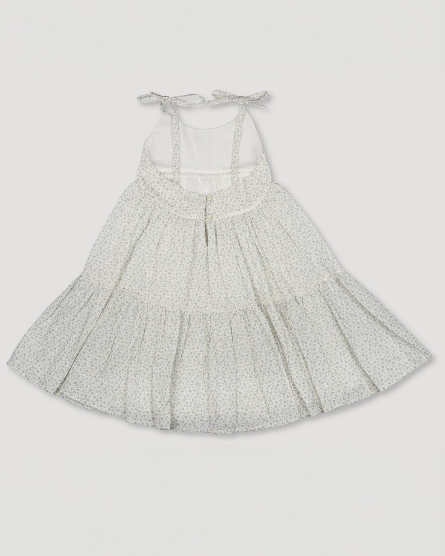 Early Sunday, Alice Dress in Mini Flower print, made from Printed canvas 70% Cotton 30% Linen fabric, featuring sleeveless with adjustable tie-up straps and a tiered silhouette, shown in a back flat-lay view