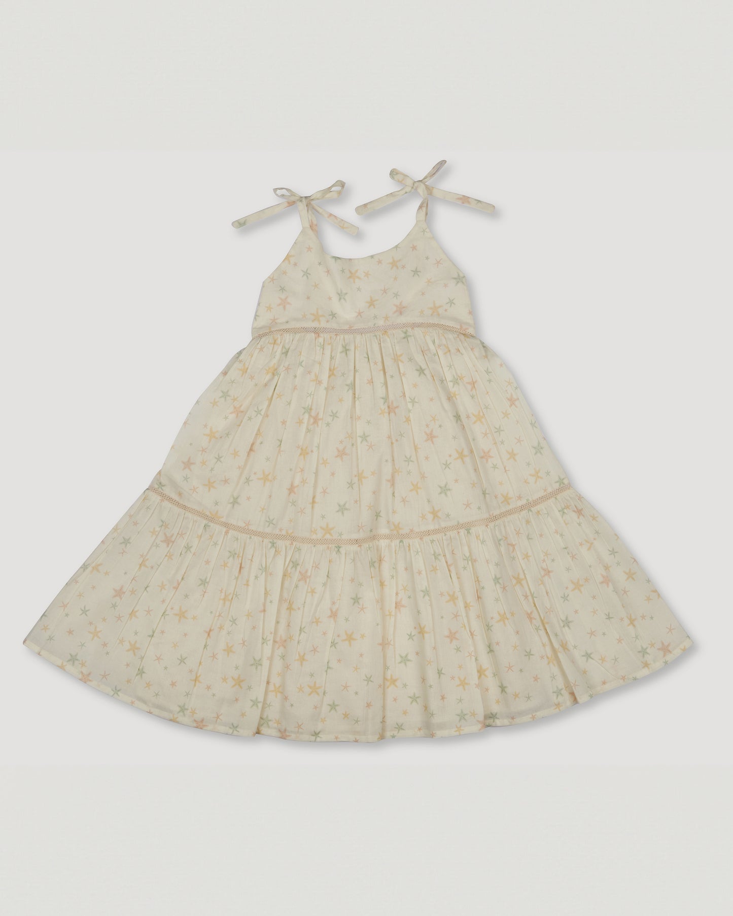 Early Sunday, Alice Dress in Star Fish print, made from Printed Cotton Cambric fabric, featuring sleeveless with adjustable tie-up straps and a tiered silhouette, shown in a front flat-lay view