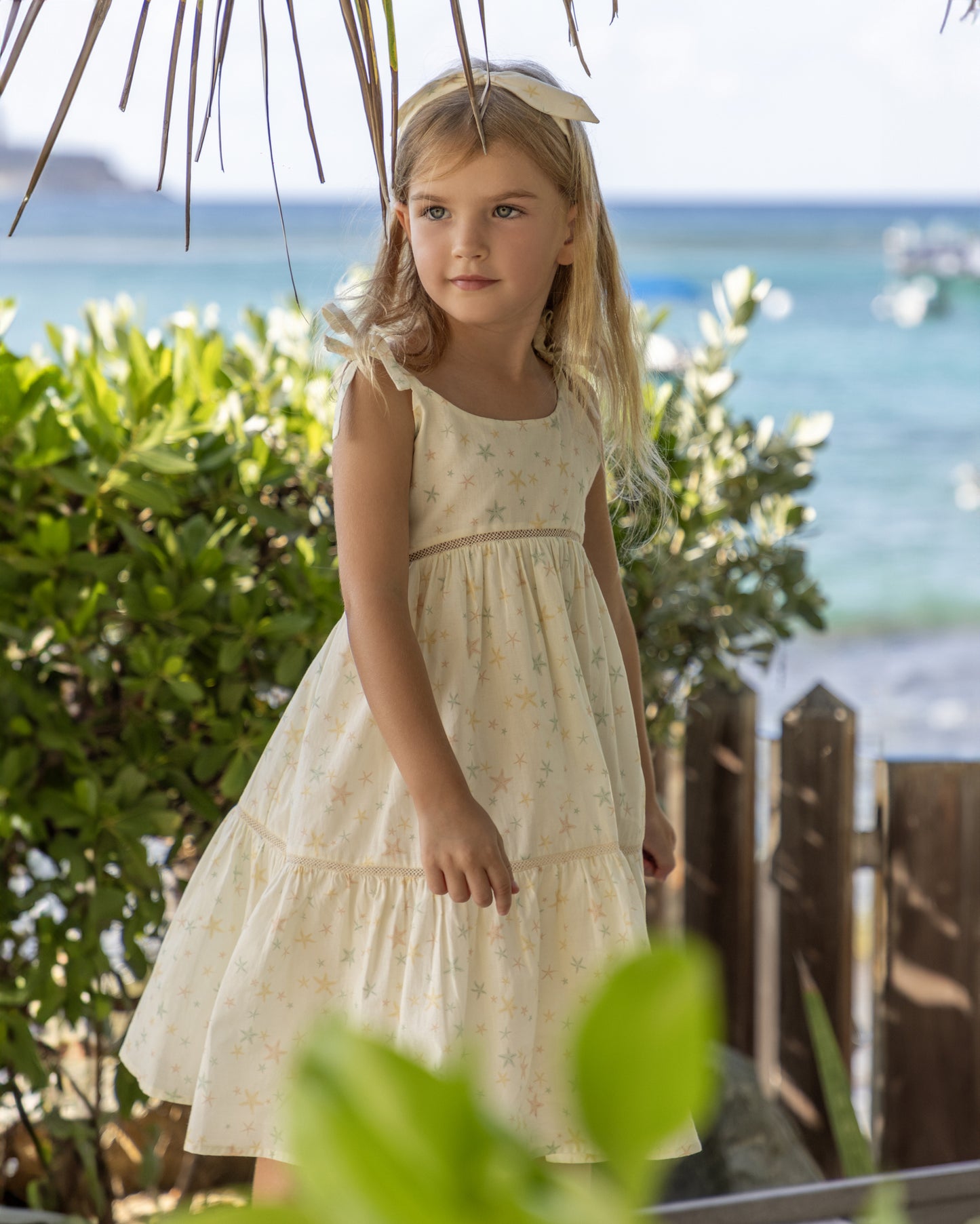 Early Sunday, Alice Dress in Star Fish print, made from Printed Cotton Cambric fabric, featuring sleeveless with adjustable tie-up straps and a tiered silhouette, shown in a front view of a model wearing it