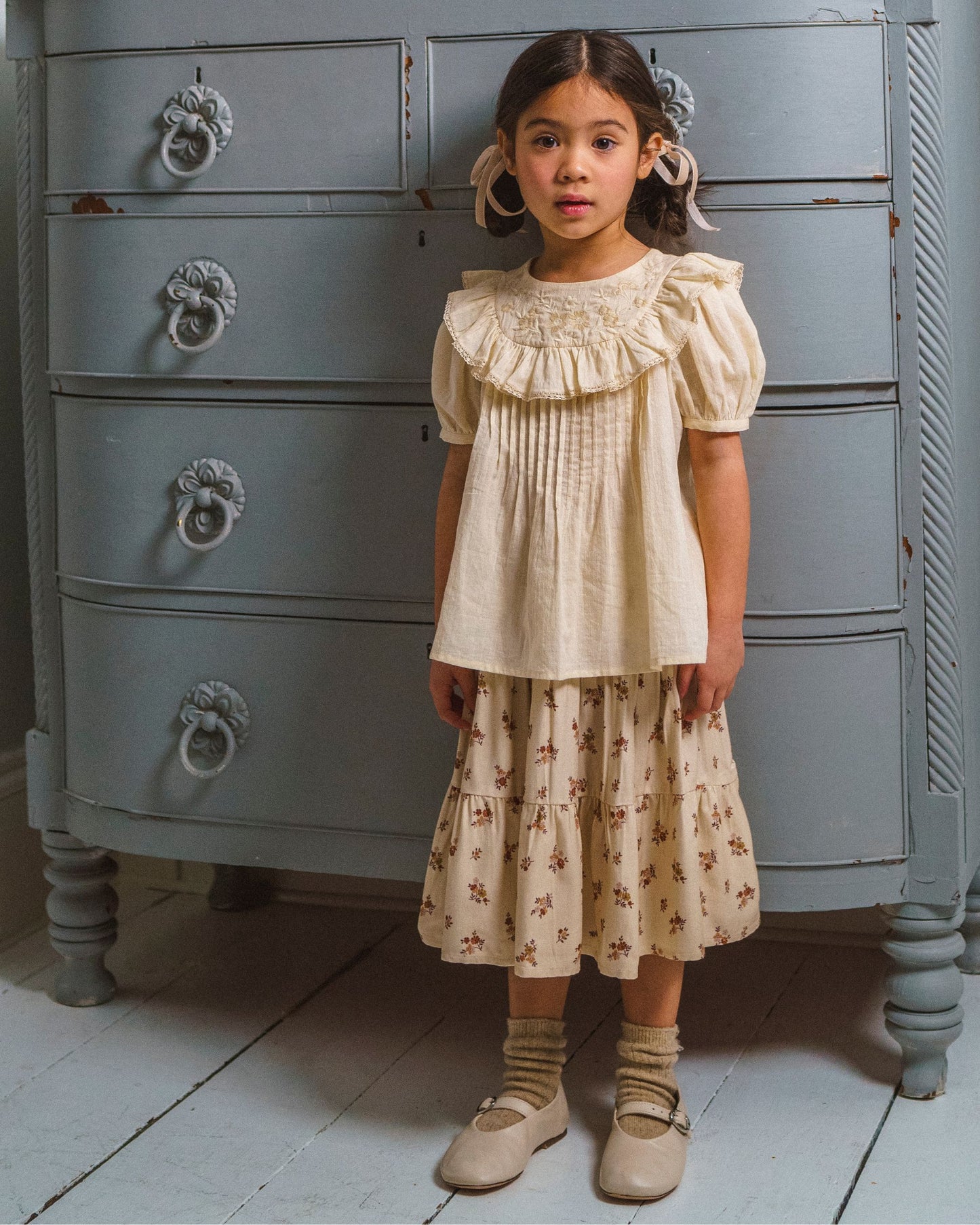 Early Sunday, Amelia Blouse in Hazelnut Cream, made from Dyed Cotton Swiss Dobby Tiny Dots fabric, featuring Classic pleats that enhance the fit and finish, shown in a front view of a model wearing it in a studio setting