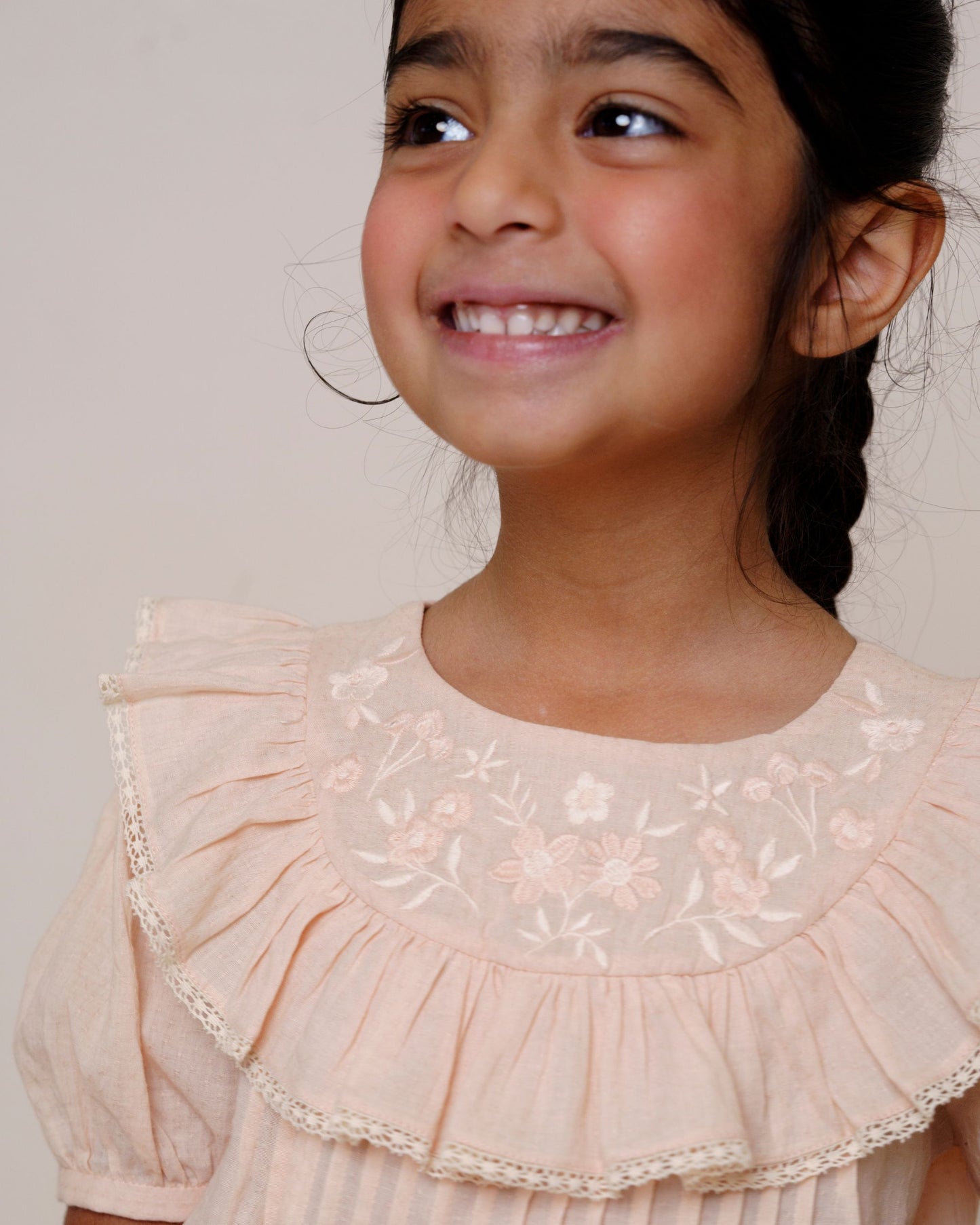 Early Sunday, Amelia Blouse in Nude, made from Dyed Cotton Swiss Dobby Tiny Dots fabric, featuring Classic pleats that enhance the fit and finish, shown in a close-up shot of a model wearing it during a studio shoot