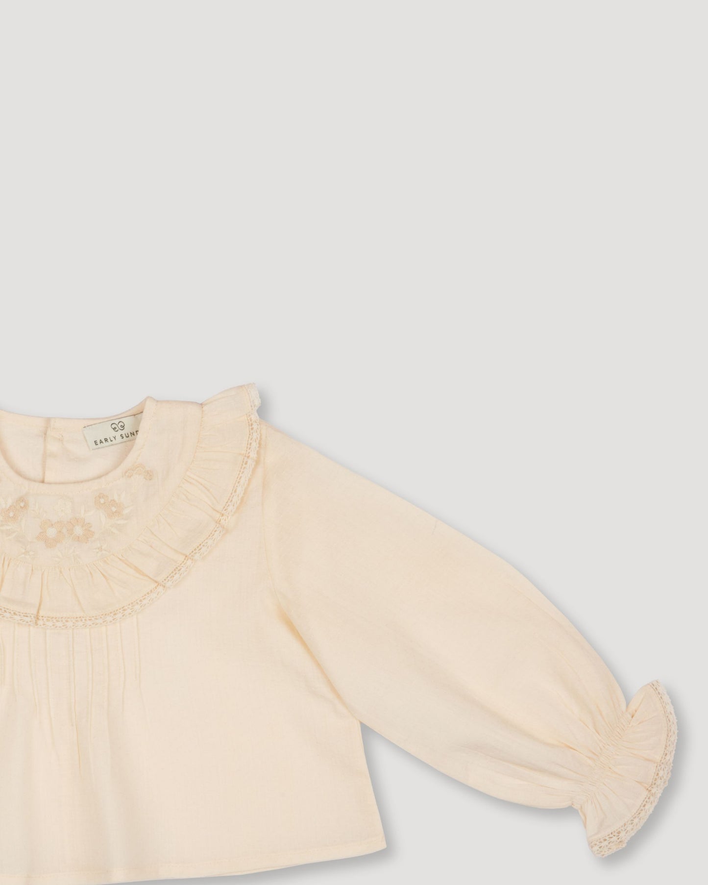 Early Sunday, Amy Baby Blouse & Bloomer Set in Hazelnut Cream & Mini Floral print, made from Dyed Cotton Swiss Dobby Tiny Dots fabric, featuring a full sleeves with beautiful embroidery & printed floral bloomers, shown in a closeup flat-lay view