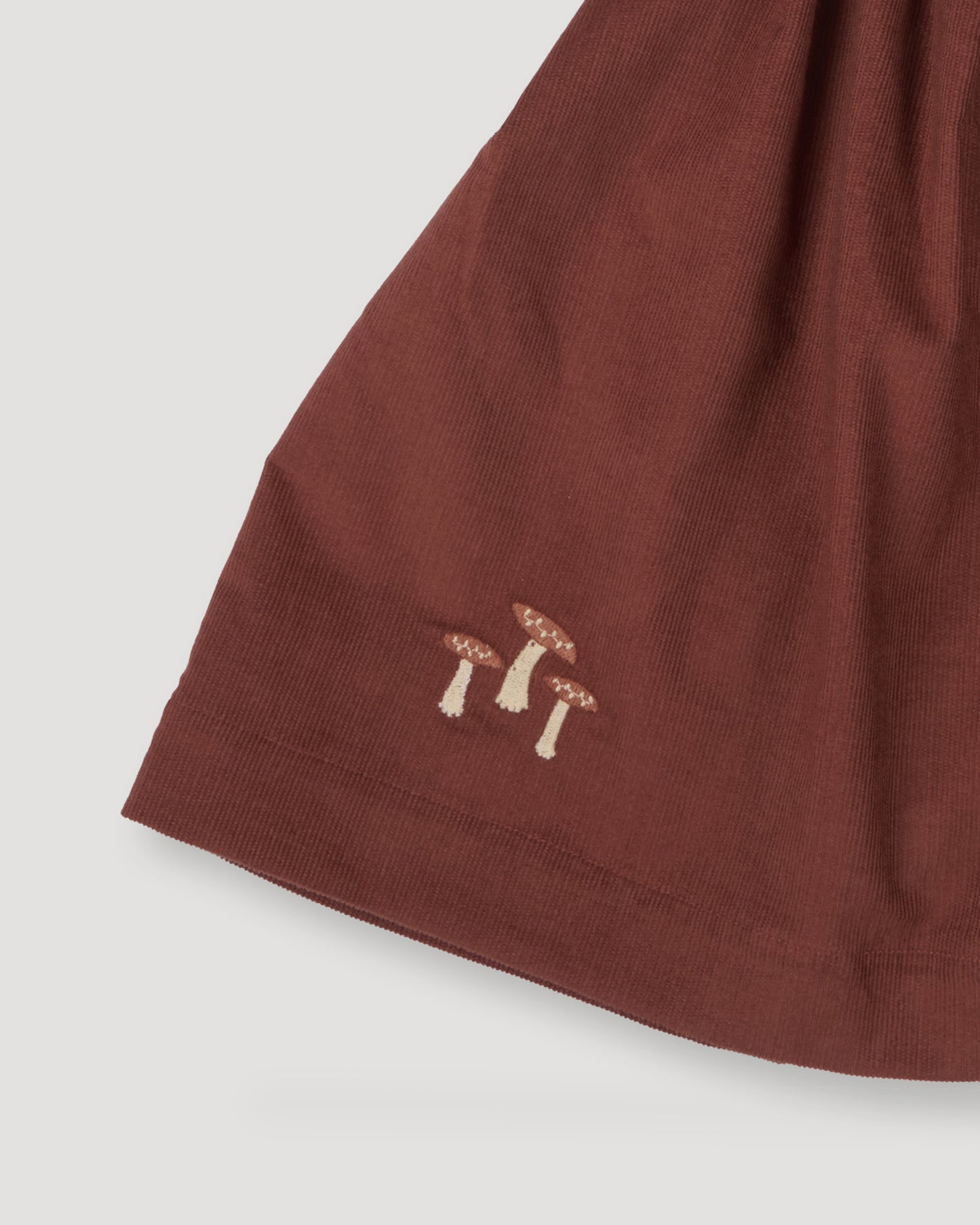 Early Sunday, Annie Skirt in Caramel color, made from Cotton Corduroy fabric, featuring a relaxed fit with an elastic waistband & beautiful embroidery, shown in a close-up shot of the print