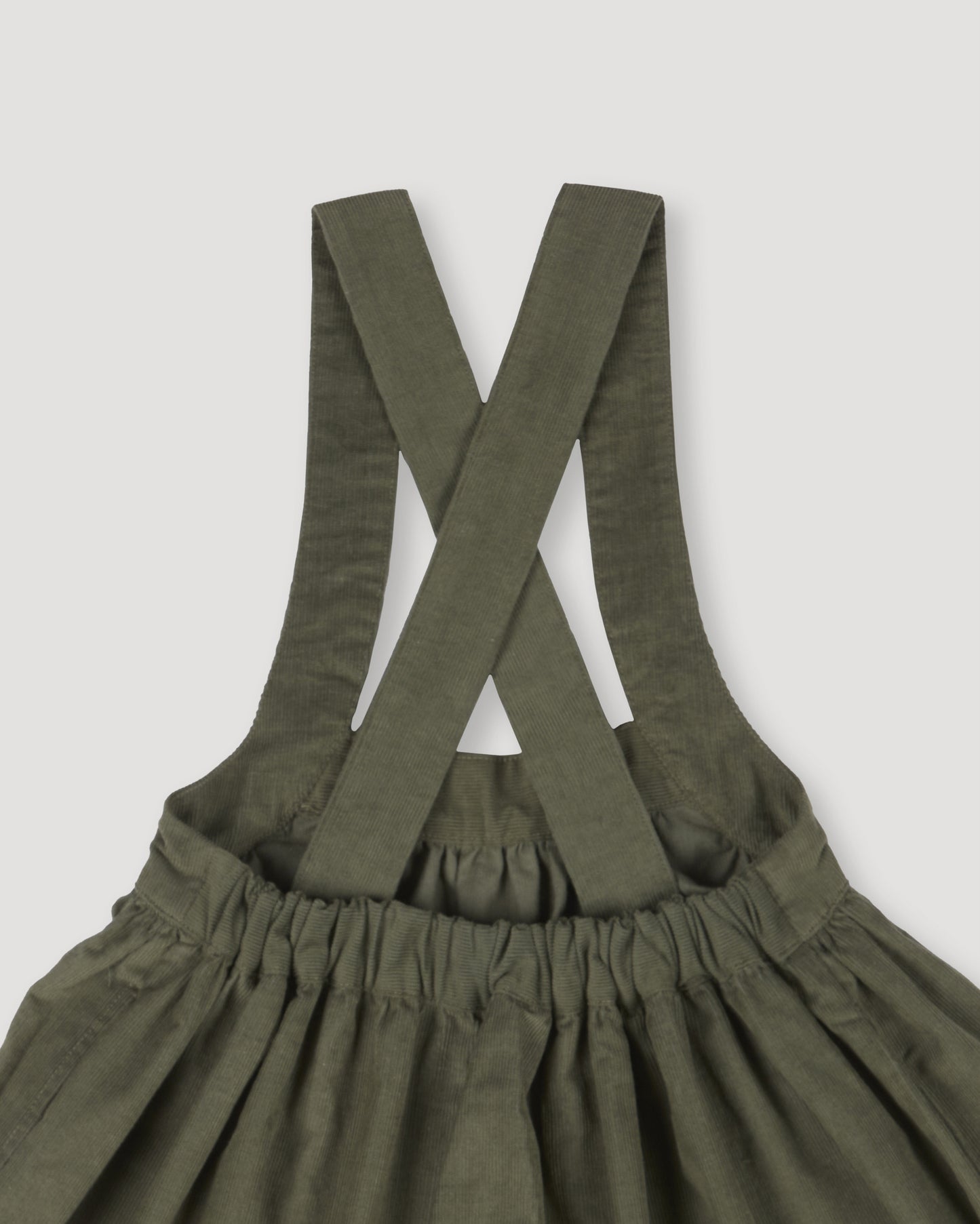 Early Sunday, Annie Skirt in Moss, made from Cotton Corduroy fabric, featuring a relaxed fit with an elastic waistband & beautiful embroidery, shown in a closeup flat-lay view