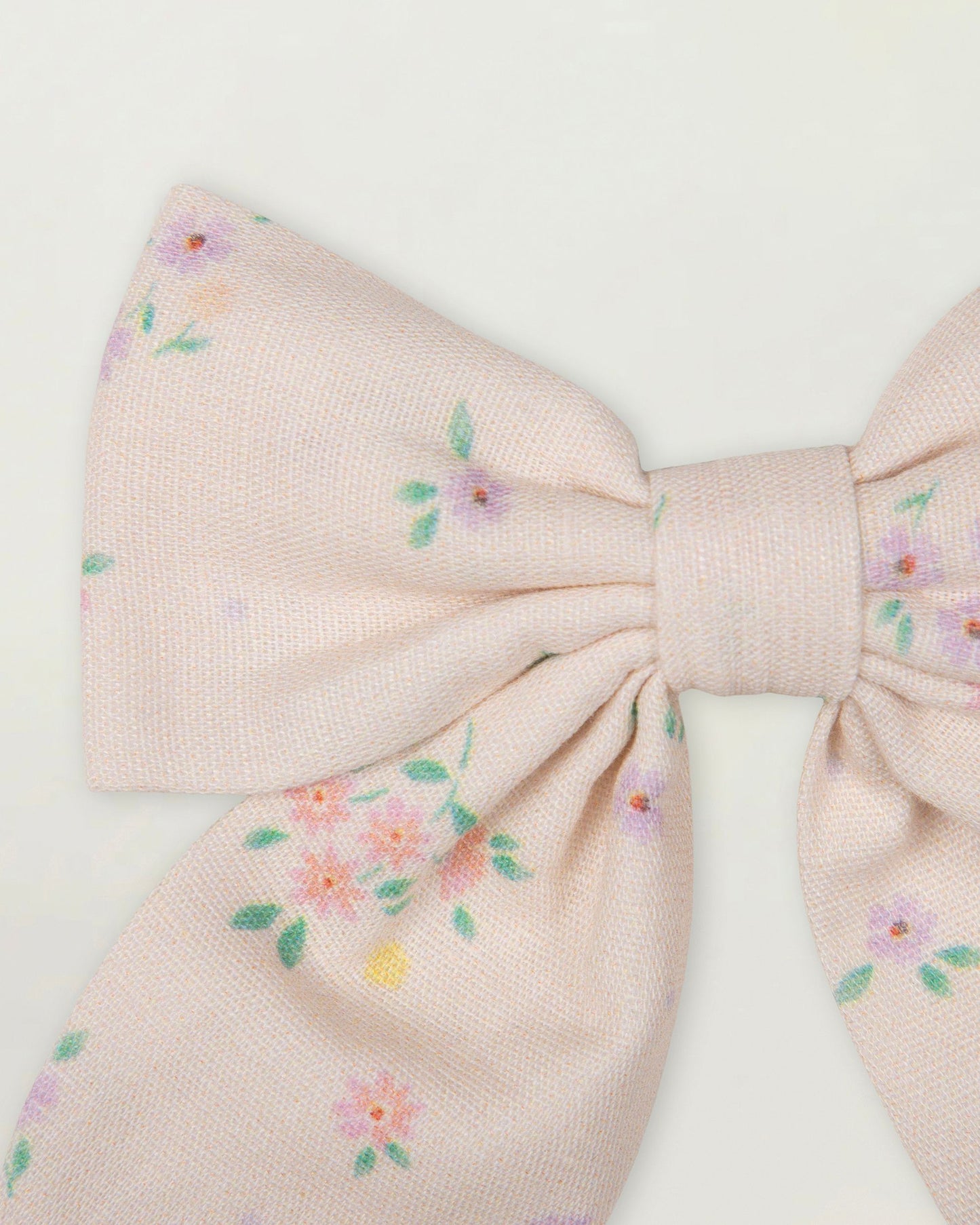 Early Sunday, Audrey Clip in Painted Bouquet print, made from Printed 70% Cotton, 30% Linen fabric, featuring a fabric bow design with a secure hair clip fastening, shown in a closeup flat-lay view