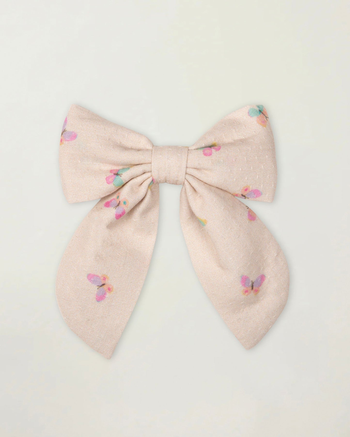 Early Sunday, Audrey Clip in Butterflies print, made from Printed Cotton Tiny Swiss Dobby fabric, featuring a fabric bow design with a secure hair clip fastening, shown in a front flat-lay view