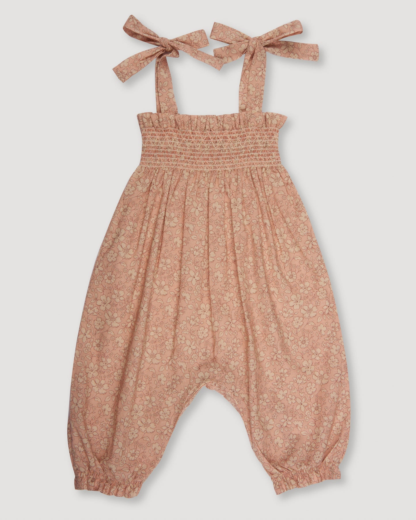 Early Sunday, Audrey Smocked Romper in Garden Flowers print, made from Printed Cotton Cambric fabric, featuring smocked chest and tie up straps, shown in a back flat-lay view