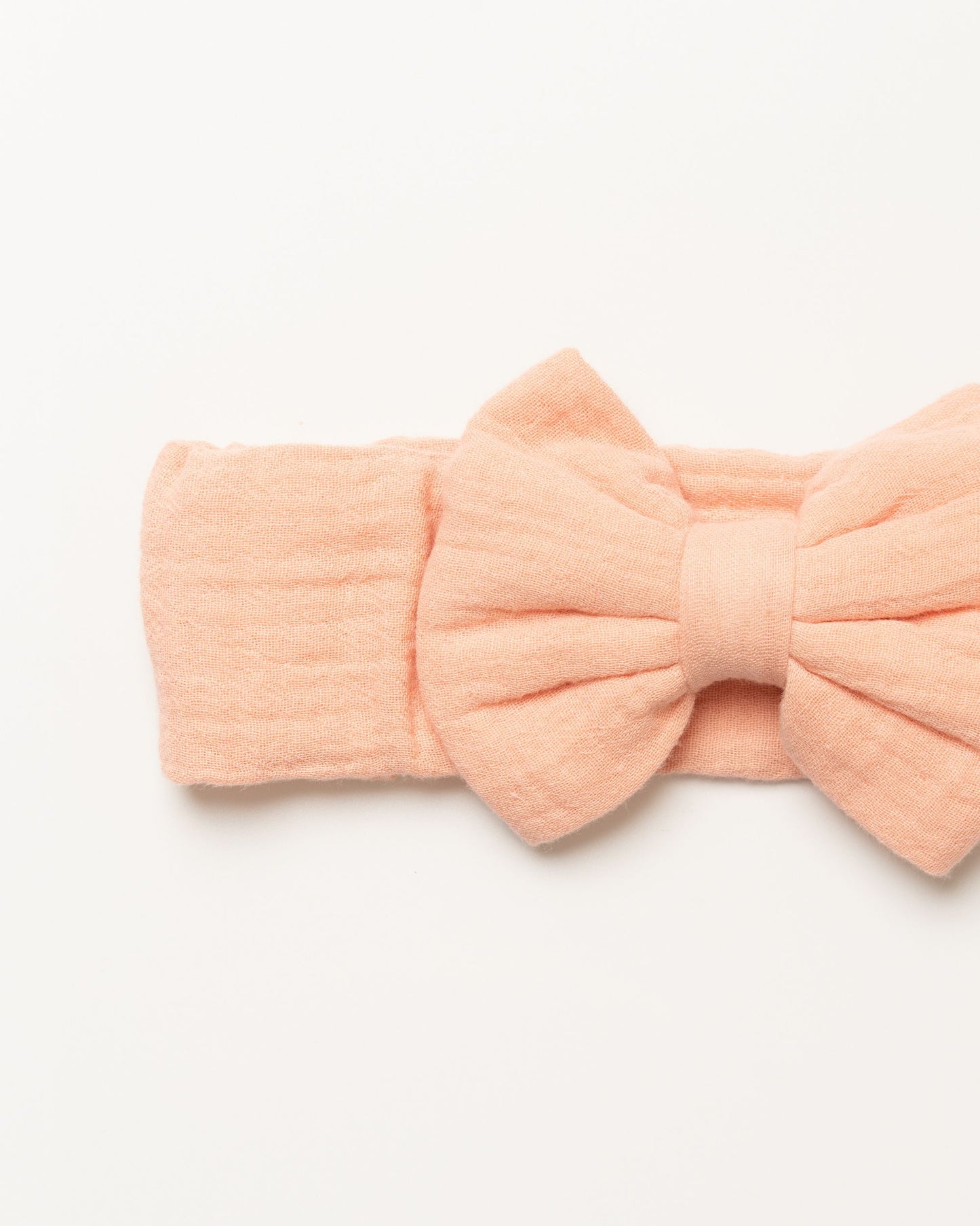 Early Sunday, Baby's Bow Headband in Candy Floss color, made from Cotton Double Gauze fabric, featuring a wide bow design, shown in a closeup flat-lay view