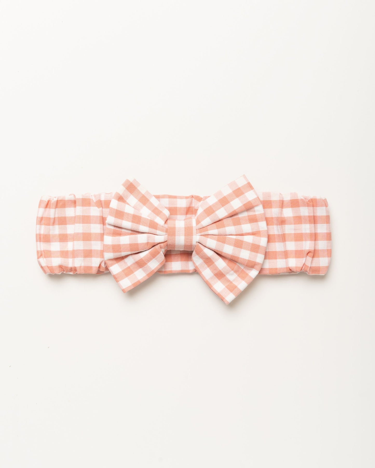 Early Sunday, Baby's Bow Headband in Peony color, made from Gingham Check fabric, featuring a wide bow design, shown in a front flat-lay view