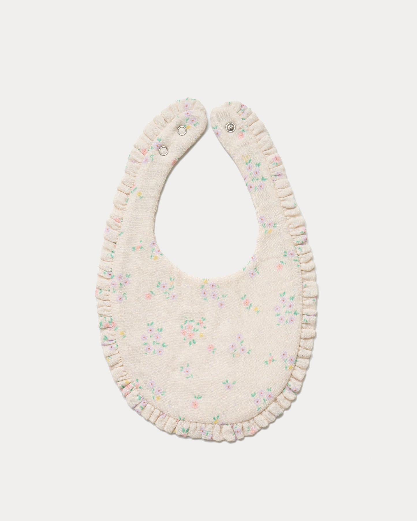 Early Sunday, Bib in Painted Bouquet print, made from Printed Cotton Double Gauze fabric, shown in a back flat-lay view