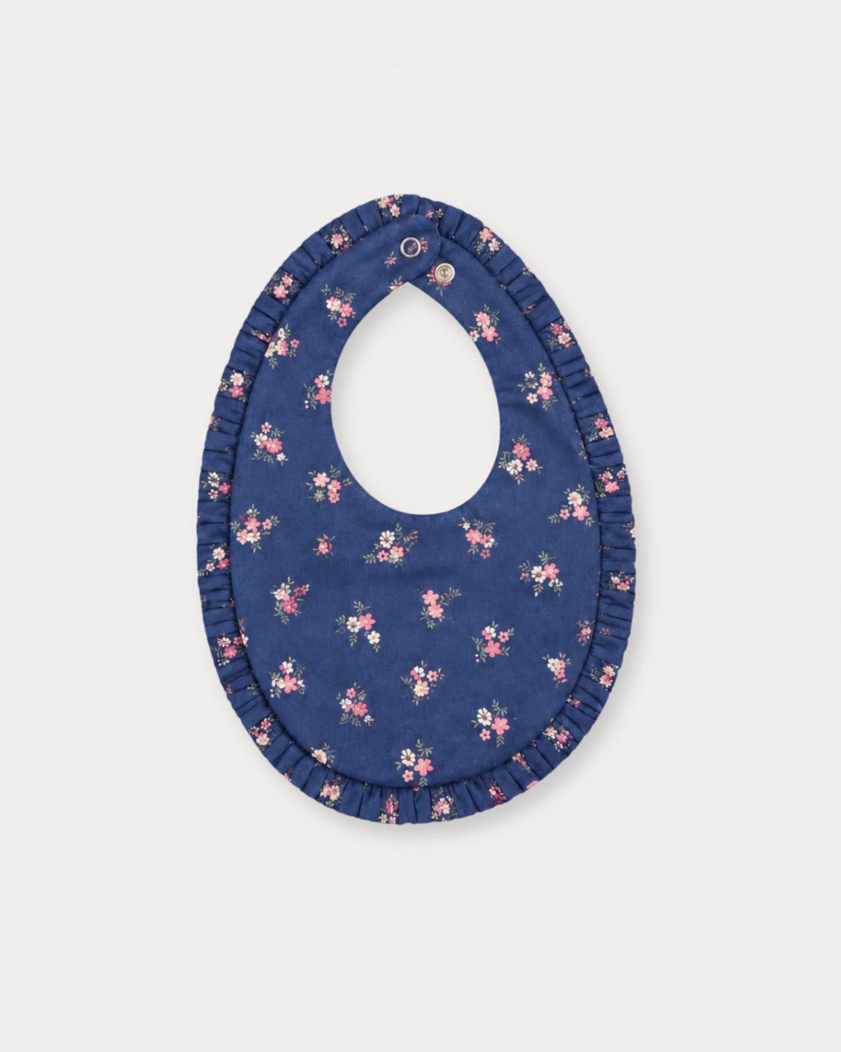 Early Sunday, Bib in Ditsy Bouquet Navy Blue, made from Printed Cotton Satin fabric, featuring featuring a soft and comfortable design with an adjustable fit, shown in a back flat-lay view