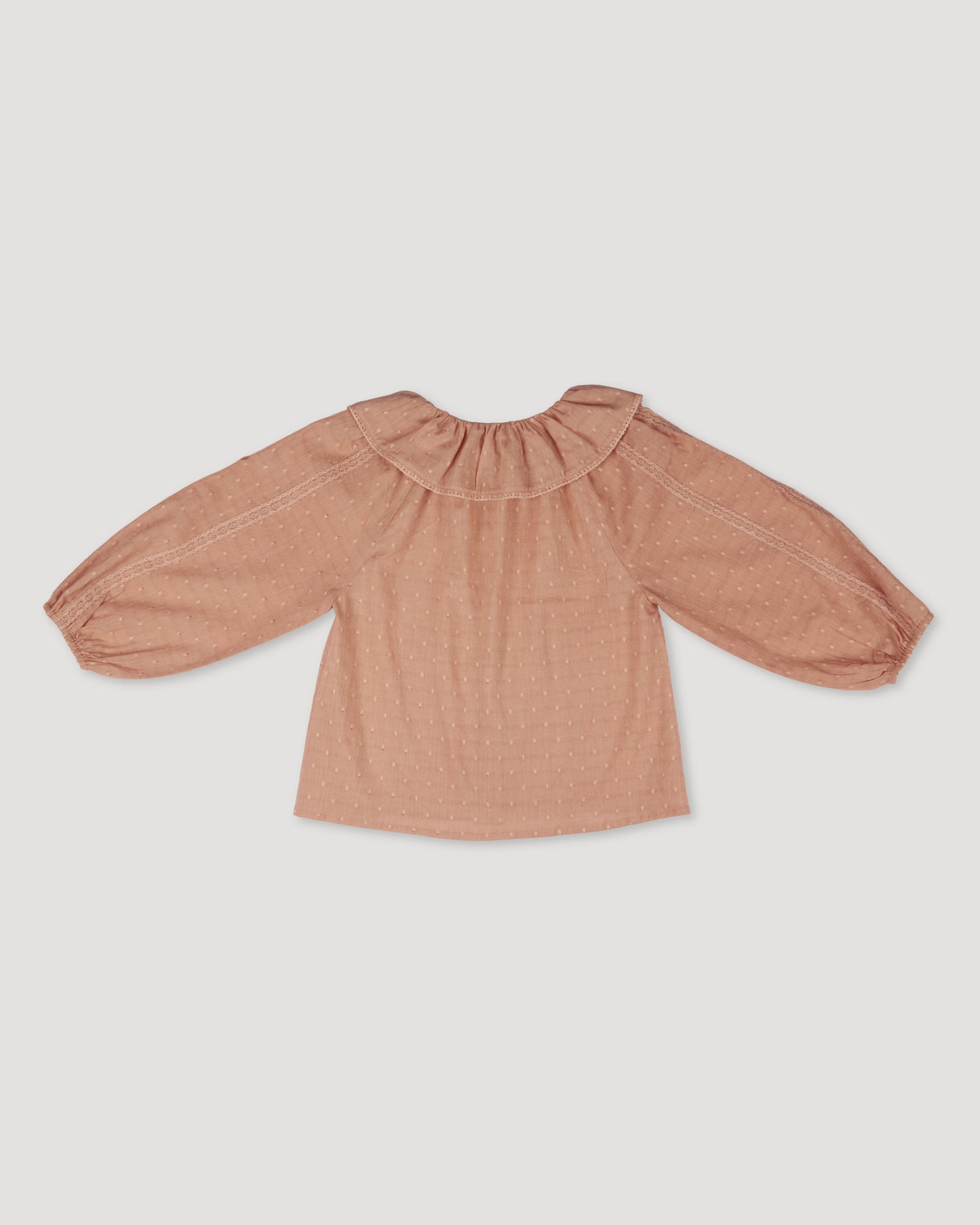 Early Sunday, Cecilia Blouse in Earthy Pink color, made from Cotton Swiss Dobby fabric, featuring relaxed fit, frill neckline, long sleeves with elasticated cuffs, and MOP buttons, shown in a back flat-lay view