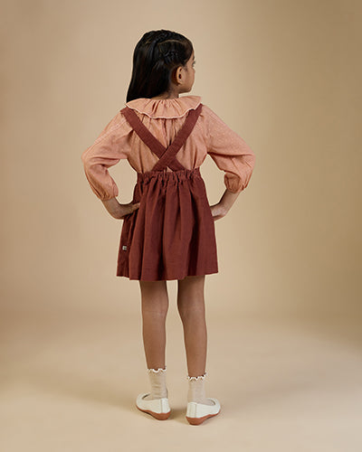 Early Sunday, Cecilia Blouse in Earthy Pink print, made from Cotton Swiss Dobby fabric, featuring relaxed fit, frill neckline, long sleeves with elasticated cuffs, and MOP buttons, shown in a back view of model wearing it