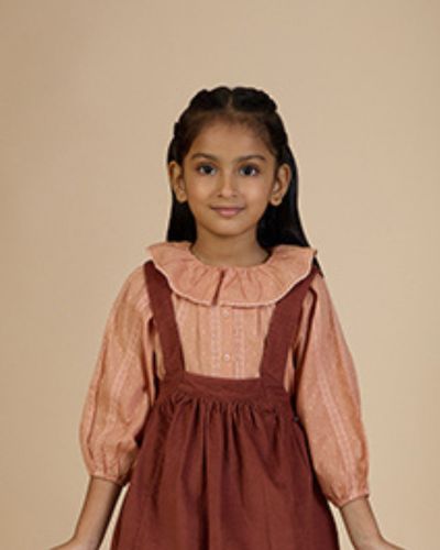 Early Sunday, Cecilia Blouse in Earthy Pink color, made from Cotton Swiss Dobby fabric, featuring relaxed fit, frill neckline, long sleeves with elasticated cuffs, and MOP buttons, shown in an angled view with a close-up shot