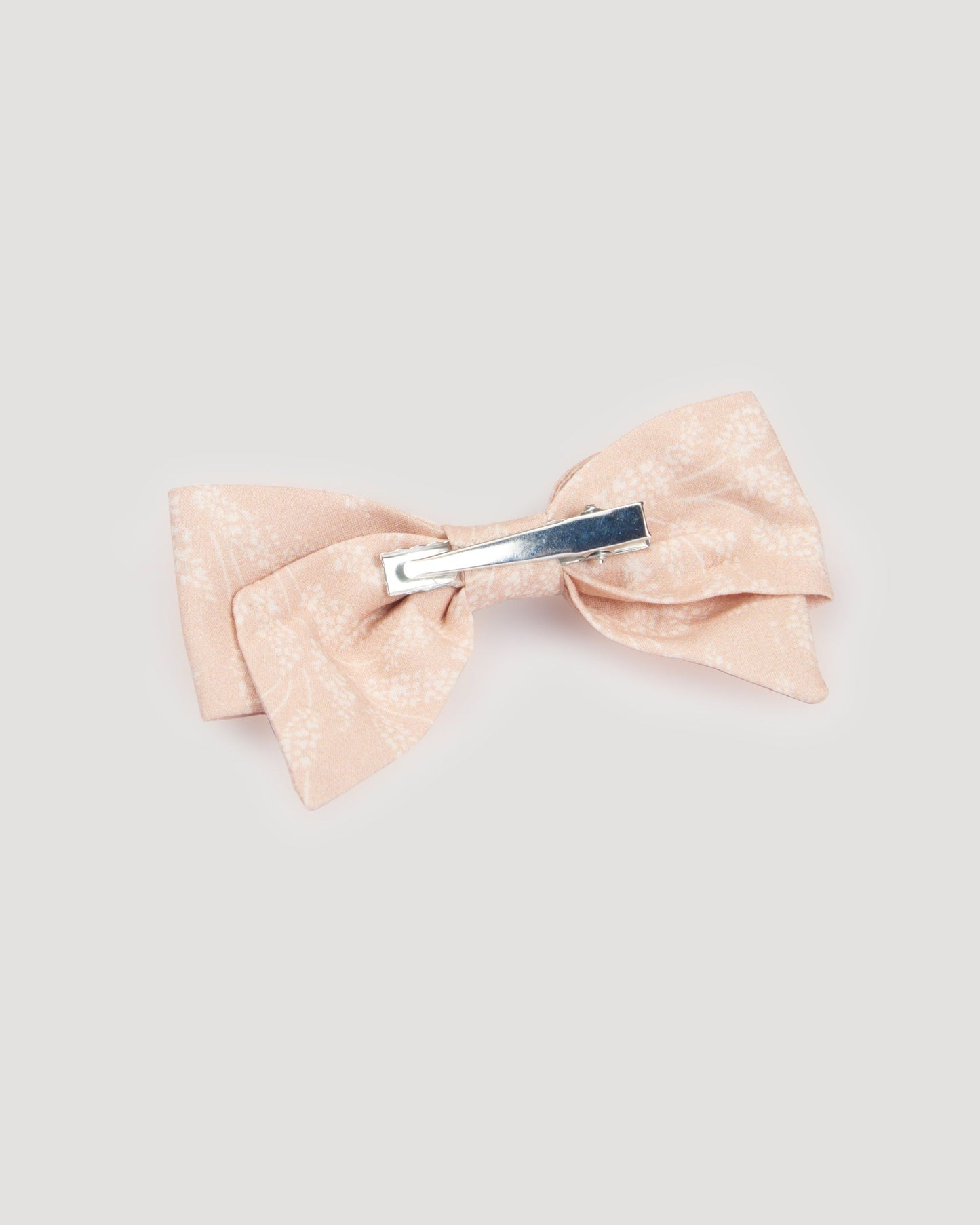 Early Sunday, Chiara Clip in Feather print, made from Printed 60s Cotton Cambric fabric, featuring a bow design on an alligator clip with a secure fit, shown in a back flat-lay view