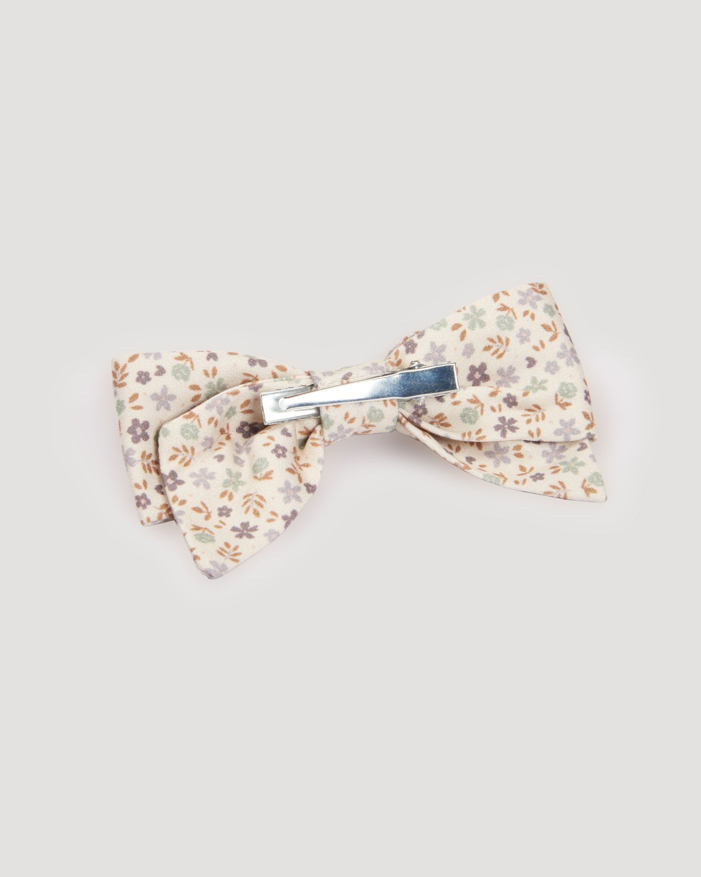 Early Sunday, Chiara Clip in Mini Flowers print, made from Printed 60s Cotton Satin fabric, featuring a bow design on an alligator clip with a secure fit, shown in a back flat-lay view