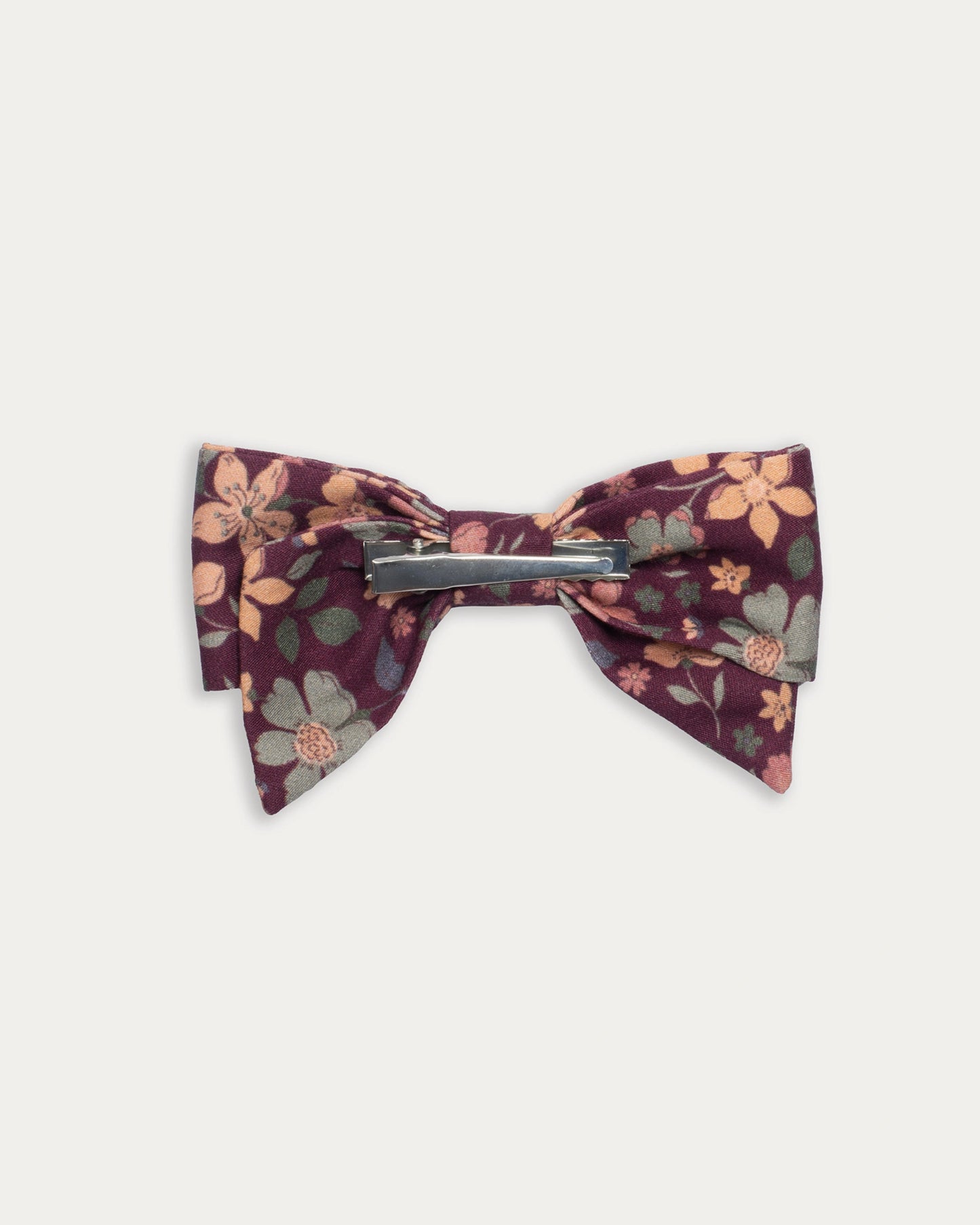 Early Sunday, Chiara Clip in Garden Flowers Plum, made from Printed Cotton Satin fabric, featuring a bow design on an alligator clip with a secure fit, shown in a back flat-lay view