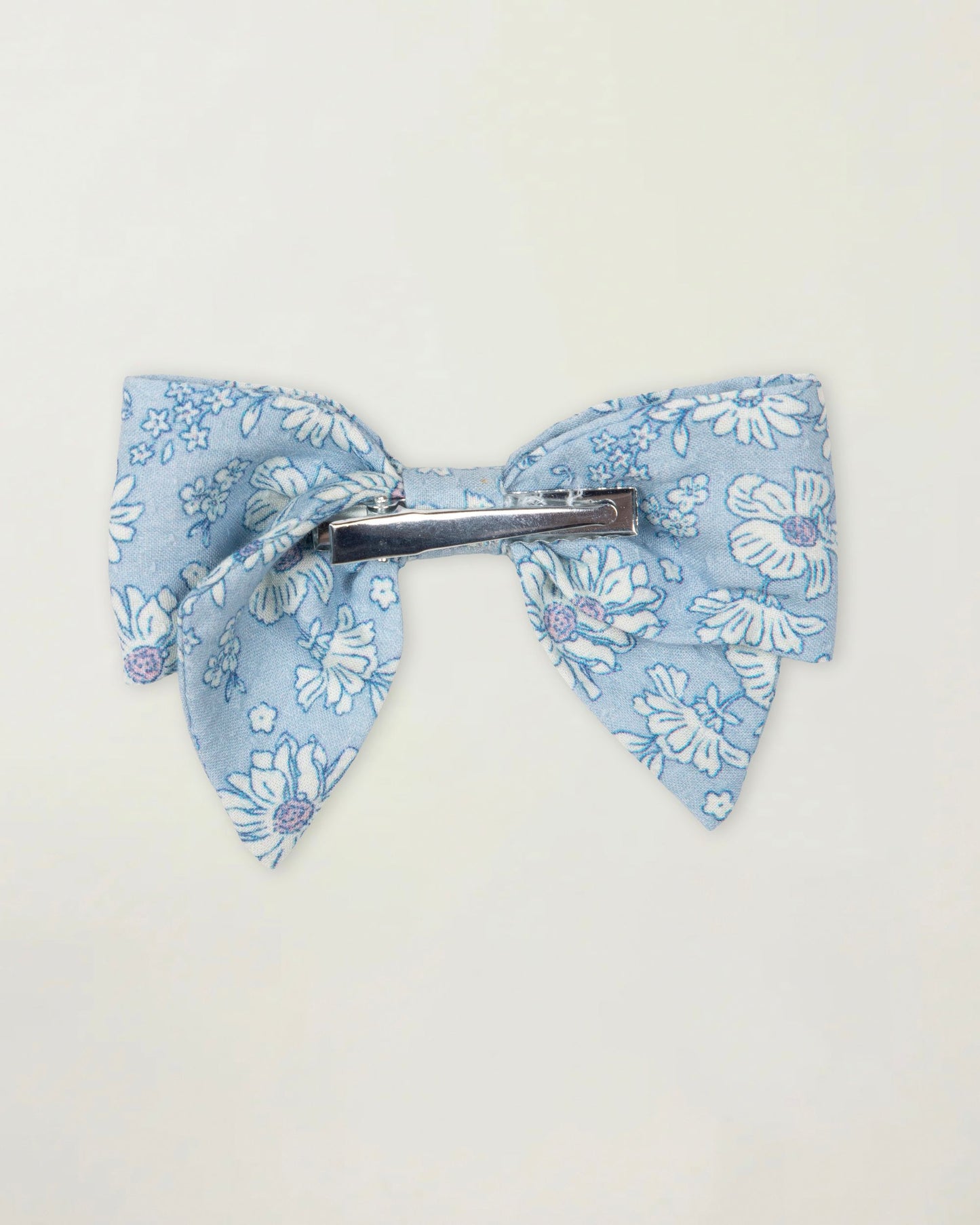 Early Sunday, Chiara Clip in Tonal Floral Blue color, made from Printed Cotton Tiny Swiss Dobby fabric, featuring a bow design on an alligator clip with a secure fit, shown in a back flat-lay view