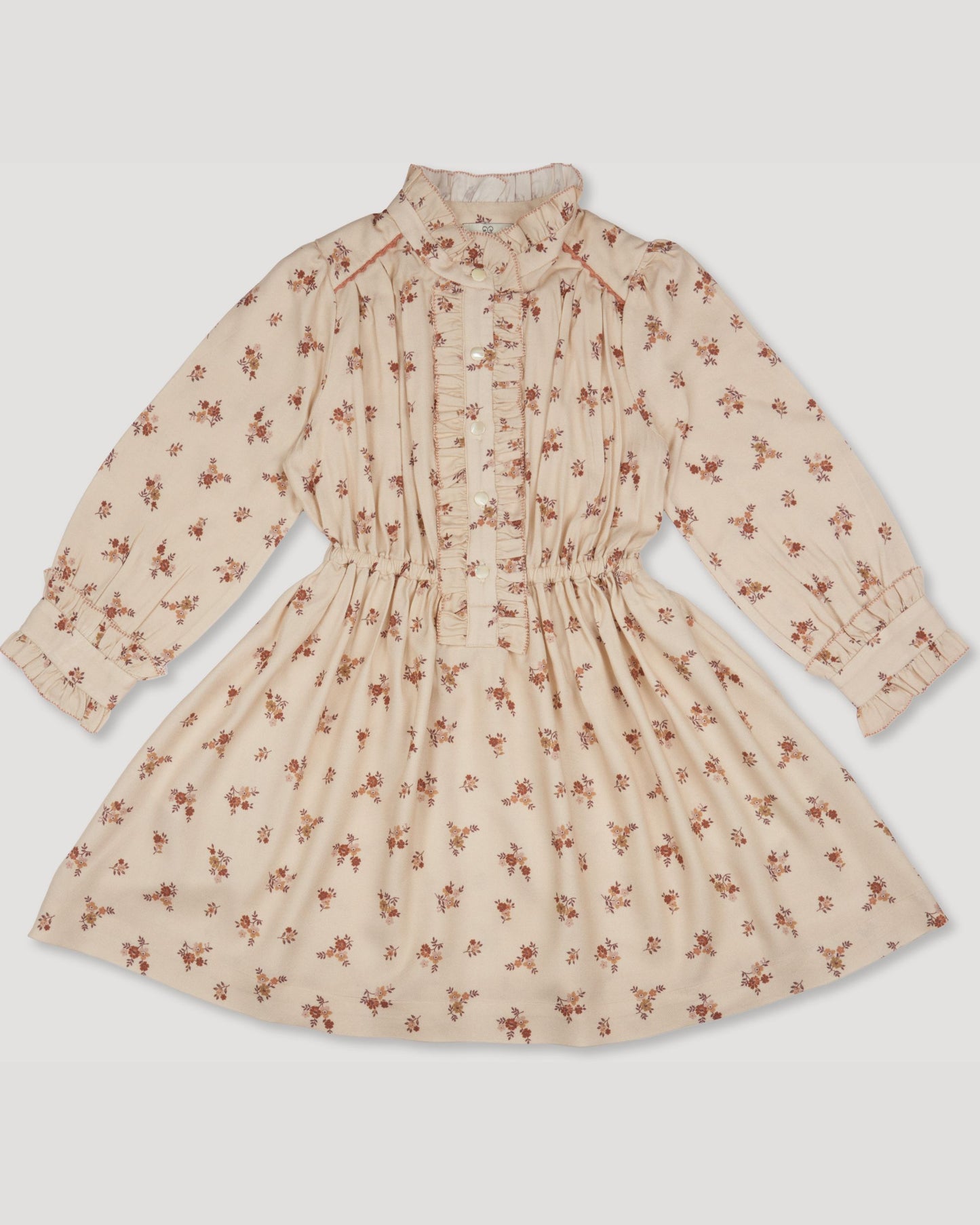 Early Sunday, Dawn Dress in Ditsy Bouquet Cream print, made from Printed Viscose Rayon Twill fabric, featuring Collar and sleeve cuffs trimmed with subtle ruffles for a nostalgic silhouette, shown in a front flat-lay view