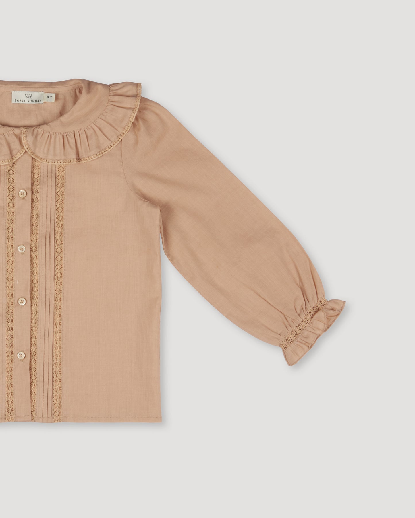Early Sunday, Ella Blouse in Nude, made from Cotton Cambric fabric, featuring relaxed fit, frill detailing on the collar, and lace inserts, shown in a closeup flat-lay view
