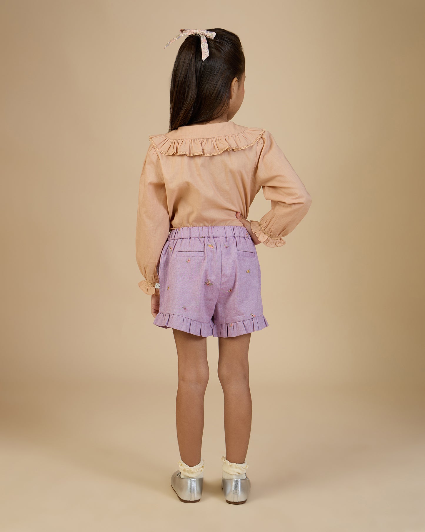 Early Sunday, Ella Blouse in Nude, made from Cotton Cambric fabric, featuring relaxed fit, frill detailing on the collar, and lace inserts, shown in a back view of model wearing it