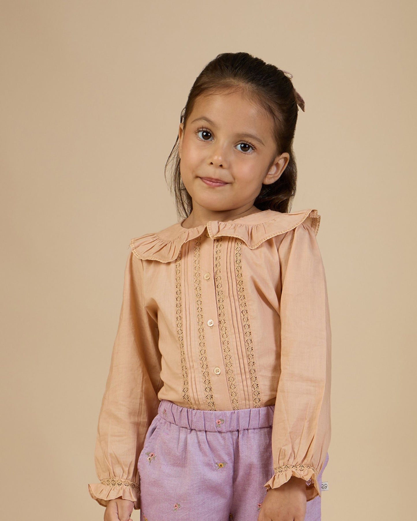 Early Sunday, Ella Blouse in Nude, made from Cotton Cambric fabric, featuring relaxed fit, frill detailing on the collar, and lace inserts, shown in a close-up side view of a model wearing it