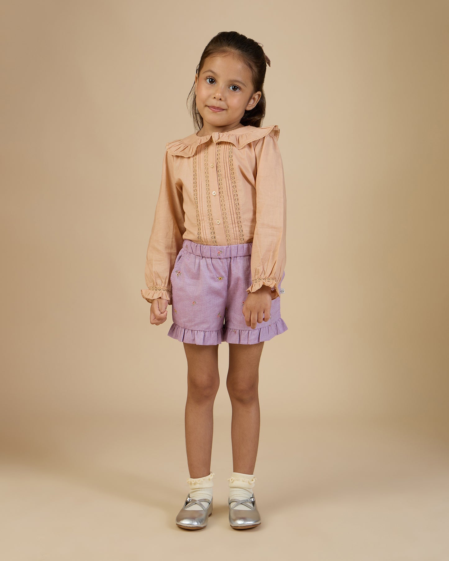 Early Sunday, Ella Blouse in Nude, made from Cotton Cambric fabric, featuring relaxed fit, frill detailing on the collar, and lace inserts, shown in a front view of model wearing it