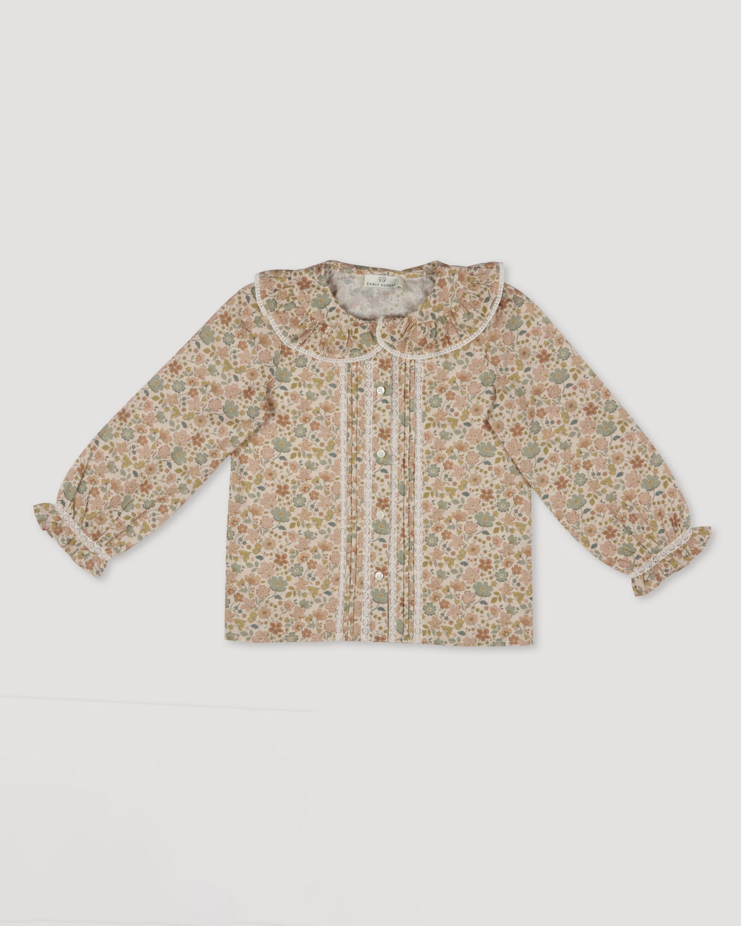 Early Sunday, Ella Blouse in Garden Flowers Cream, made from Printed Cotton Cambric fabric, featuring relaxed fit, frill detailing on the collar, and lace inserts, shown in a front flat-lay view