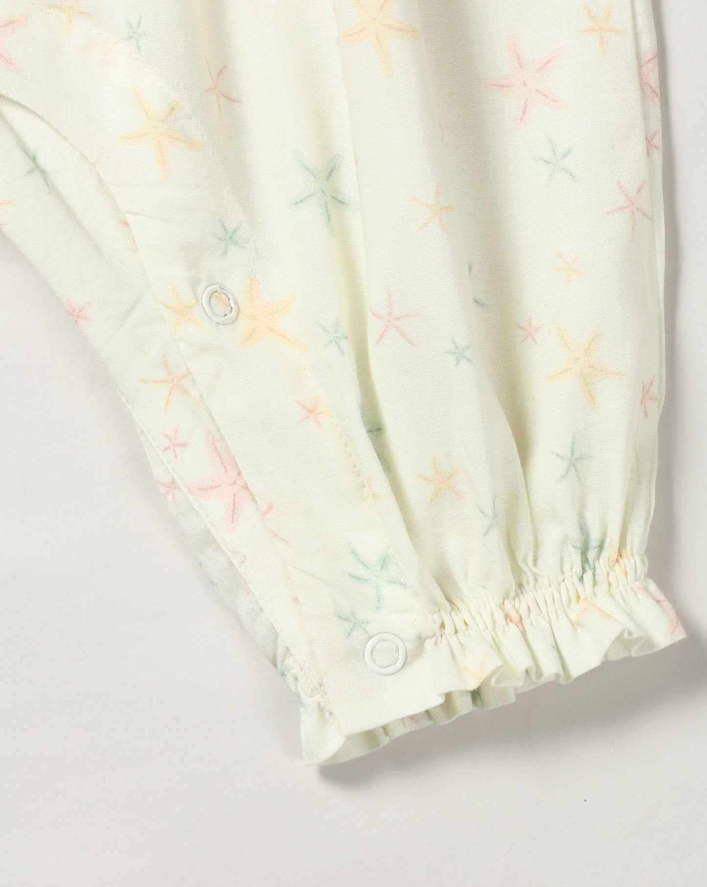 Early Sunday, Emma Baby Smocked Overalls Romper in Star Fish print, made from Printed Cotton Cambric fabric, featuring a relaxed fit with smocked chest band & frilled sleeves, shown in a closeup flat-lay view