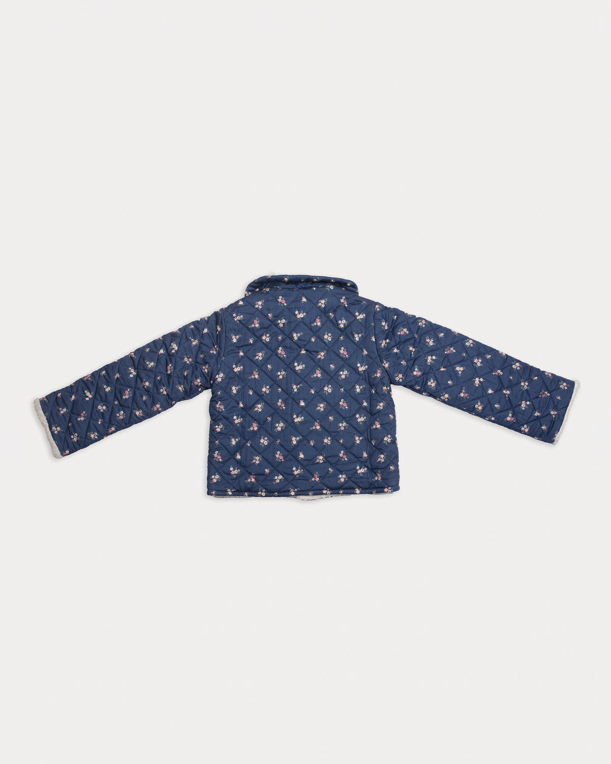 Early Sunday, Esmée Jacket in Ditsy Bouquet Navy, made from Printed Cotton Satin fabric, featuring a quilted layer with floral detailing, shown in a back flat-lay view