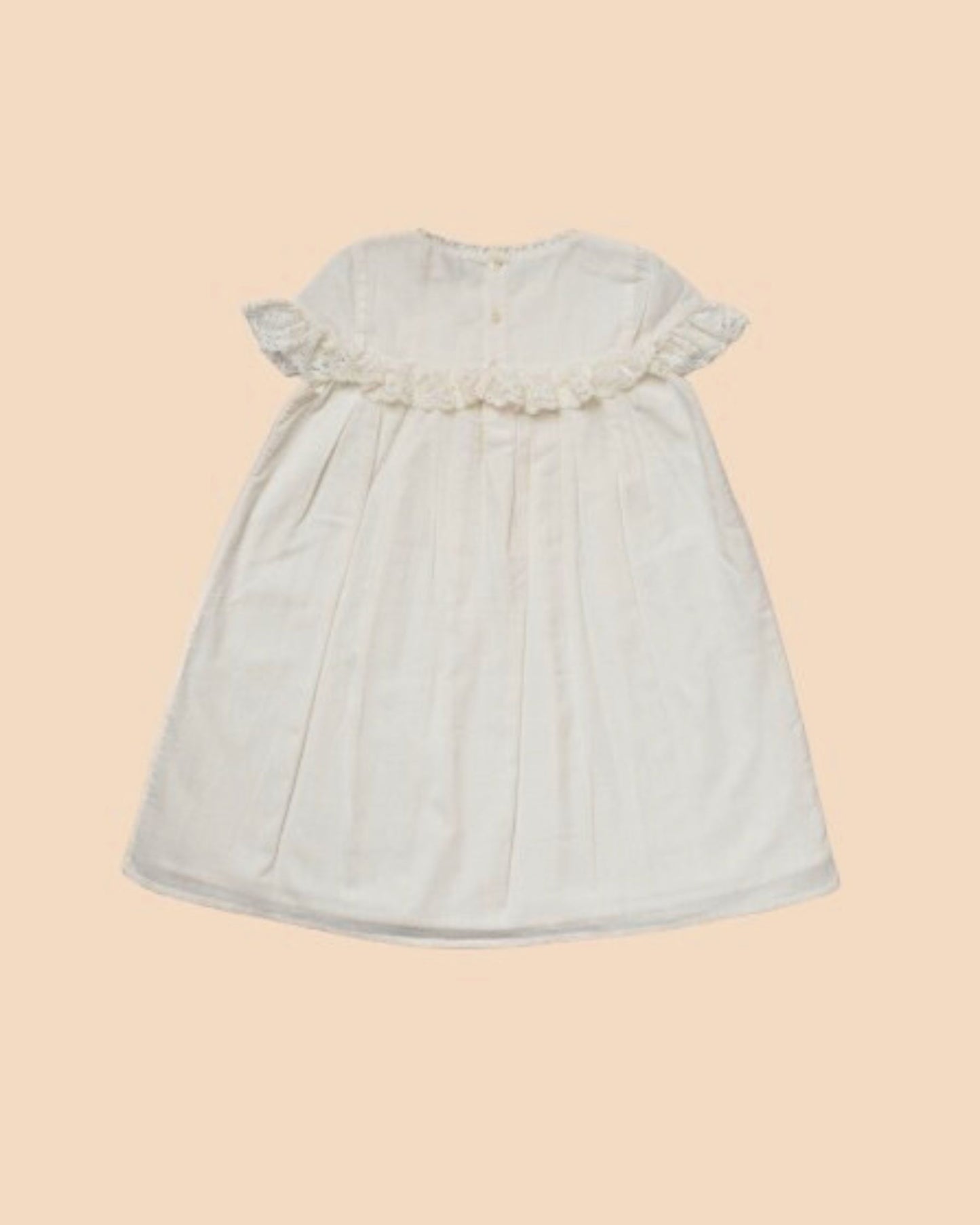 Early Sunday, Faustine Dress in Ivory color, made from 100% cotton swiss dobby tiny dots fabric, featuring Soft gathers with delicate ruffle accents, shown in a back flat-lay view