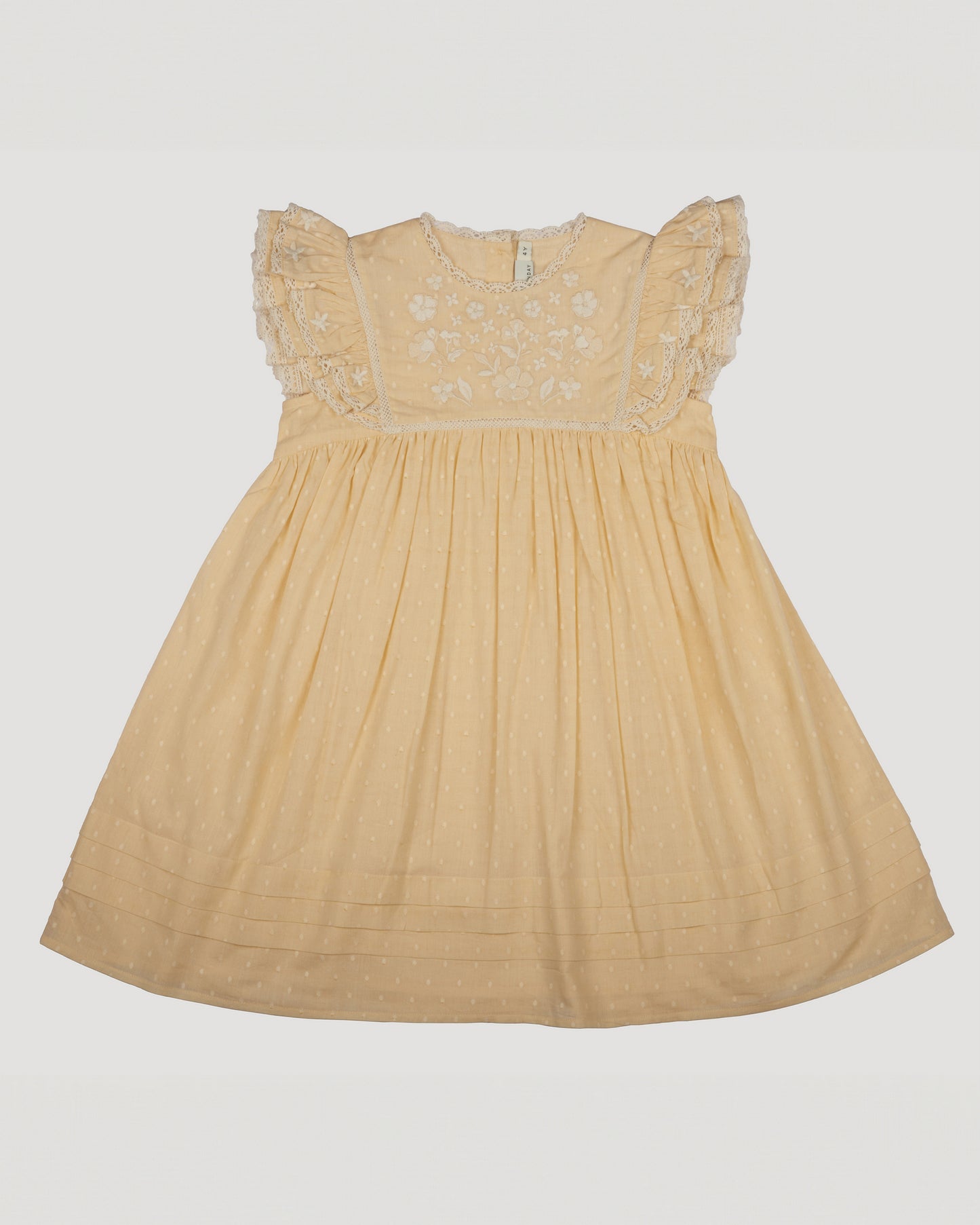 Early Sunday, Georgia Dress in Vanilla color, made from Cotton Dobby Swiss Dots fabric, featuring flutter sleeves, pintuck detailing, and a flowy, gathered silhouette, shown in a front flat-lay view