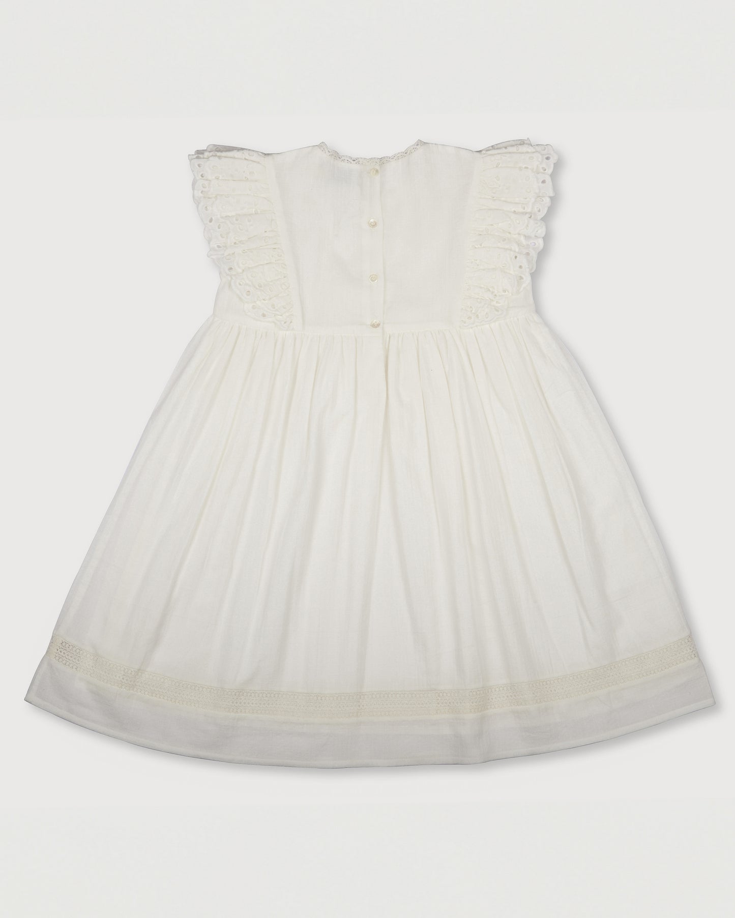 Early Sunday, Georgia Dress in Ivory print, made from Cotton Tiny Swiss Dots fabric, featuring Flutter sleeves, pintuck detailing, and a flowy, gathered silhouette, shown in a back flat-lay view
