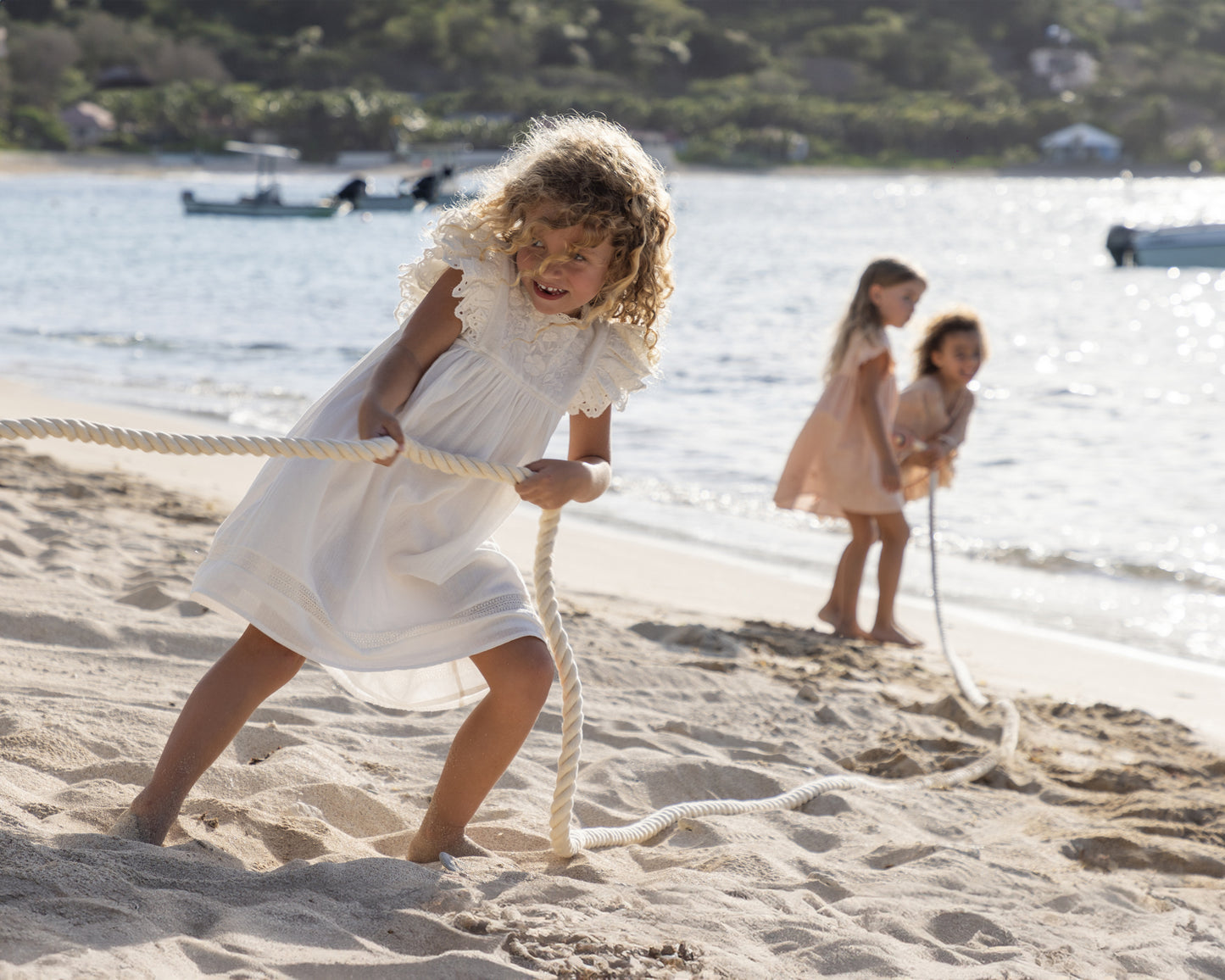 Early Sunday, Georgia Dress in Ivory color, made from Cotton Tiny Swiss Dots fabric, featuring flutter sleeves, pintuck detailing, and a flowy, gathered silhouette, shown in a front view of model wearing it