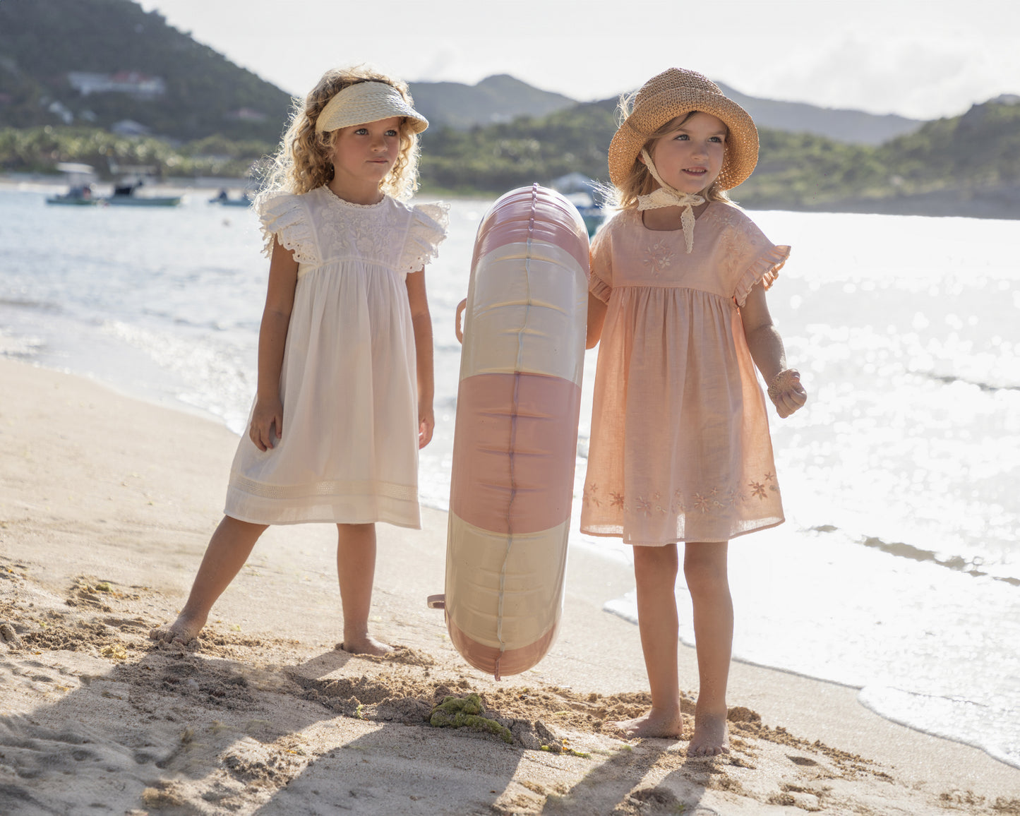 Early Sunday, Georgia Dress in Ivory color, made from Cotton Tiny Swiss Dots fabric, featuring Flutter sleeves, pintuck detailing, and a flowy, gathered silhouette, shown in a front view of models playing outdoors
