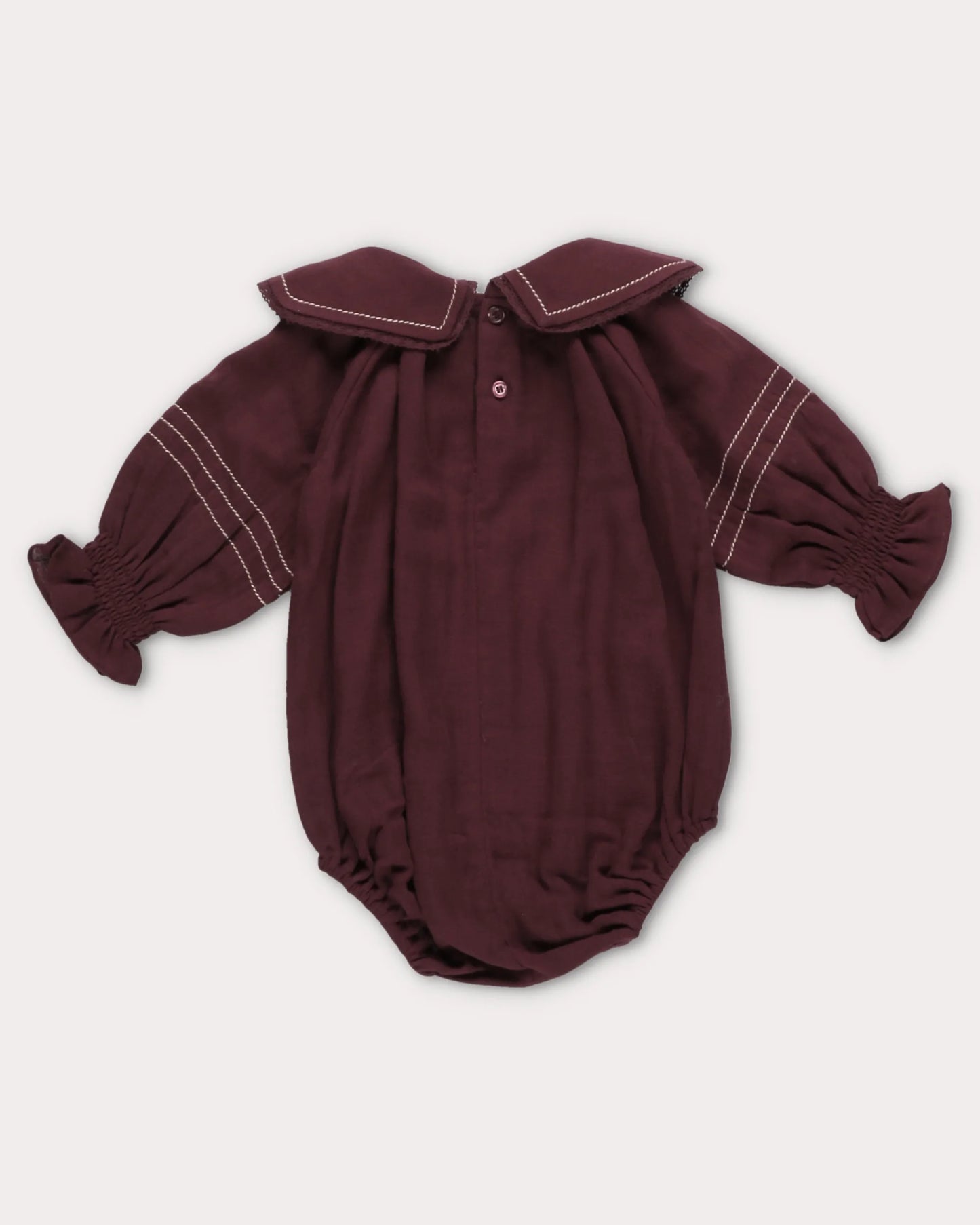 Early Sunday, Gladys Baby Bubble Romper in Plum, made from Cotton Double Gauze fabric, featuring a floral embroidered collar with beautiful lace yoke, shown in a back flat-lay view