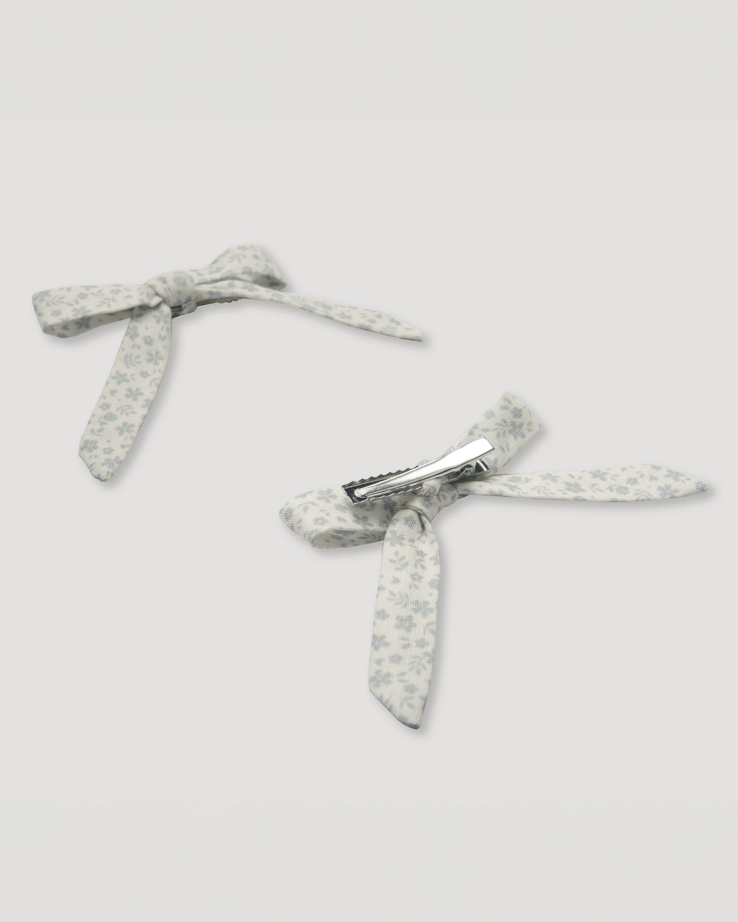 Early Sunday, Chiara Alligator Clip in Mini Flower print, made from Printed canvas 70% Cotton 30% Linen fabric, featuring a bow design on an alligator clip with a secure fit, shown in a back flat-lay view