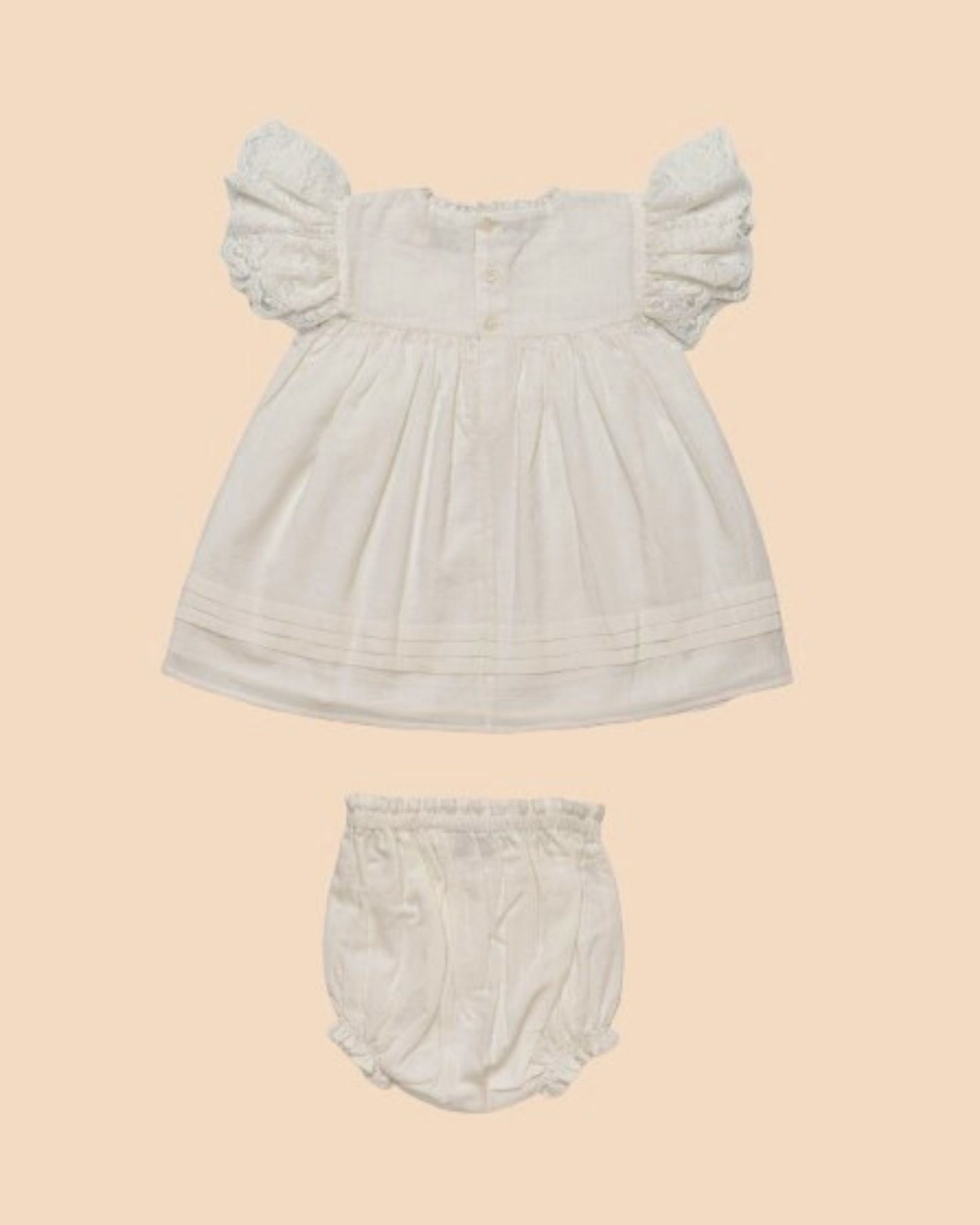 Early Sunday, Grace Baby Dress & Bloomer Set in Ivory color, made from 100% Cotton Swiss Dobby fabric, featuring a sleeveless design with wide shoulder straps & matching bloomers, shown in a back flat-lay view