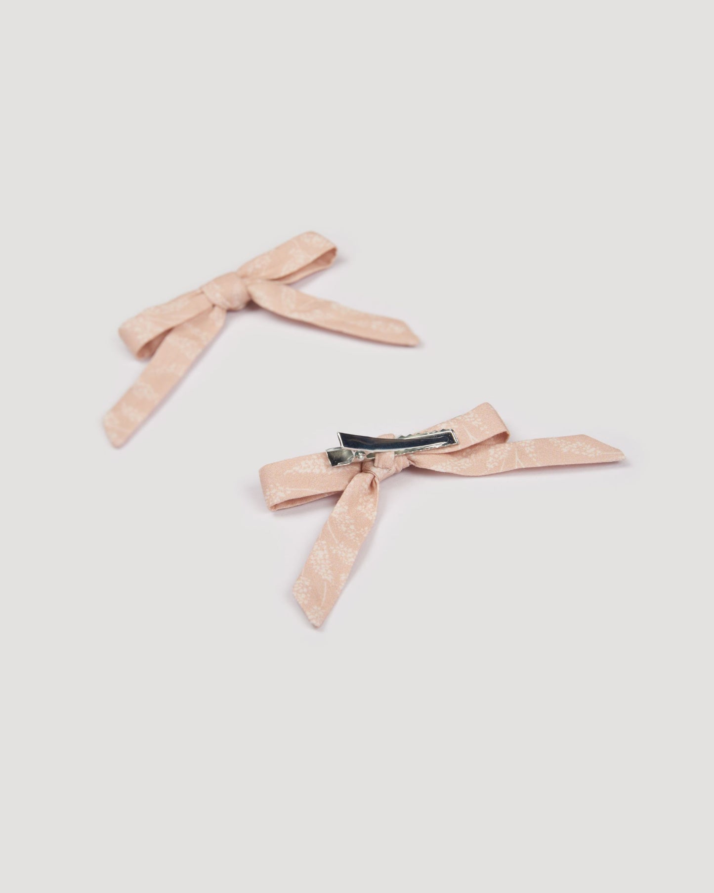 Early Sunday, Grace Clip in Feather print, made from Printed 60s Cotton Cambric fabric, featuring a set of two bow clips with a secure fit, shown in a back flat-lay view