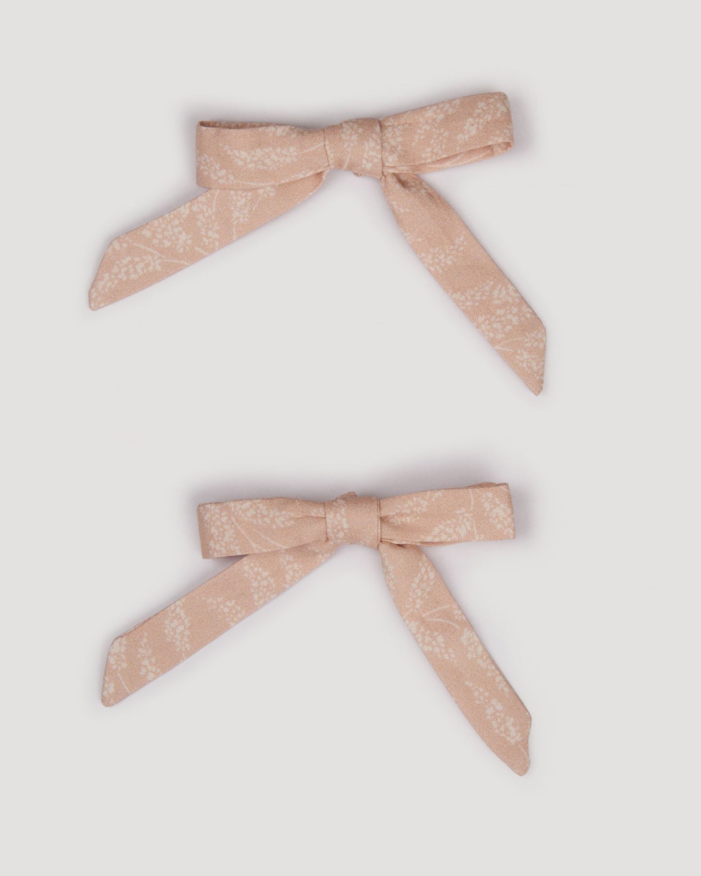 Early Sunday, Grace Clip in Feather print, made from Printed 60s Cotton Cambric fabric, featuring a set of two bow clips with a secure fit, shown in a front flat-lay view