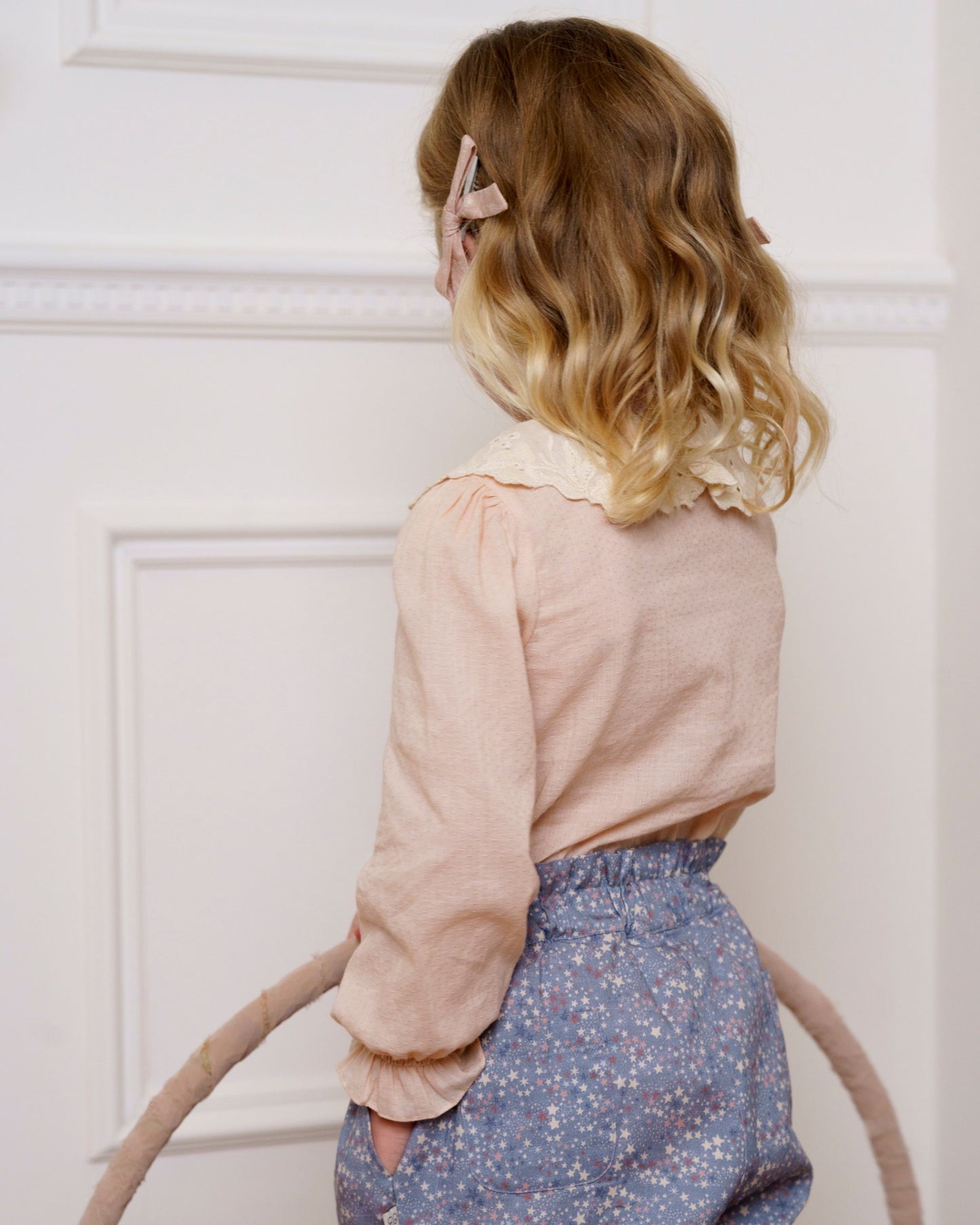 Early Sunday, Grace Clip in Feather print, made from Printed 60s Cotton Cambric fabric, featuring a set of two bow clips with a secure fit, shown in a back view of model wearing it