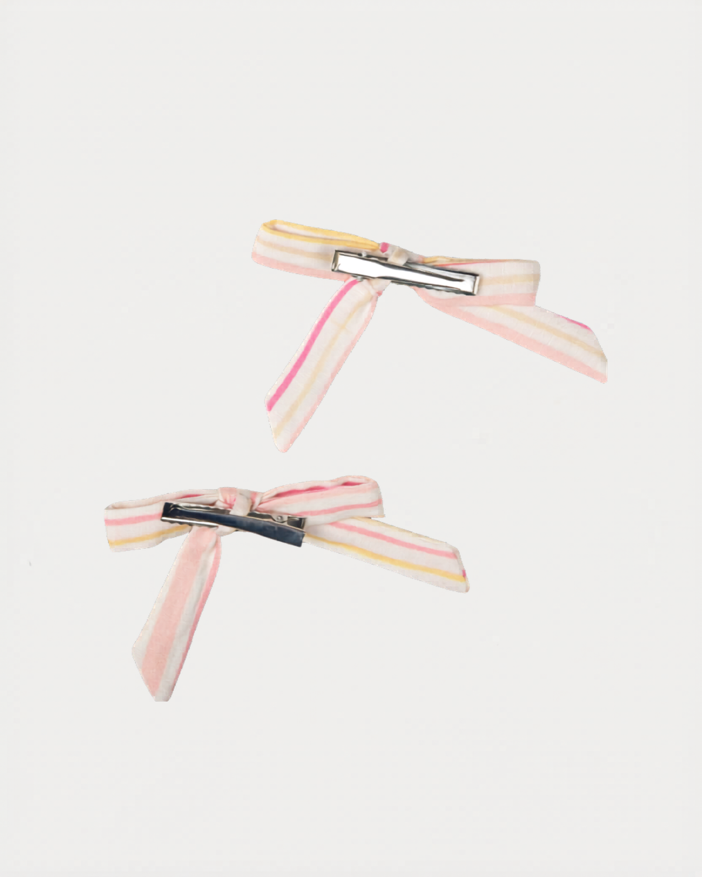 Early Sunday, Grace Clip in Pink Stripes print, made from Printed 70% Cotton, 30% Linen fabric, featuring a set of two bow clips with a secure fit, shown in a back flat-lay view