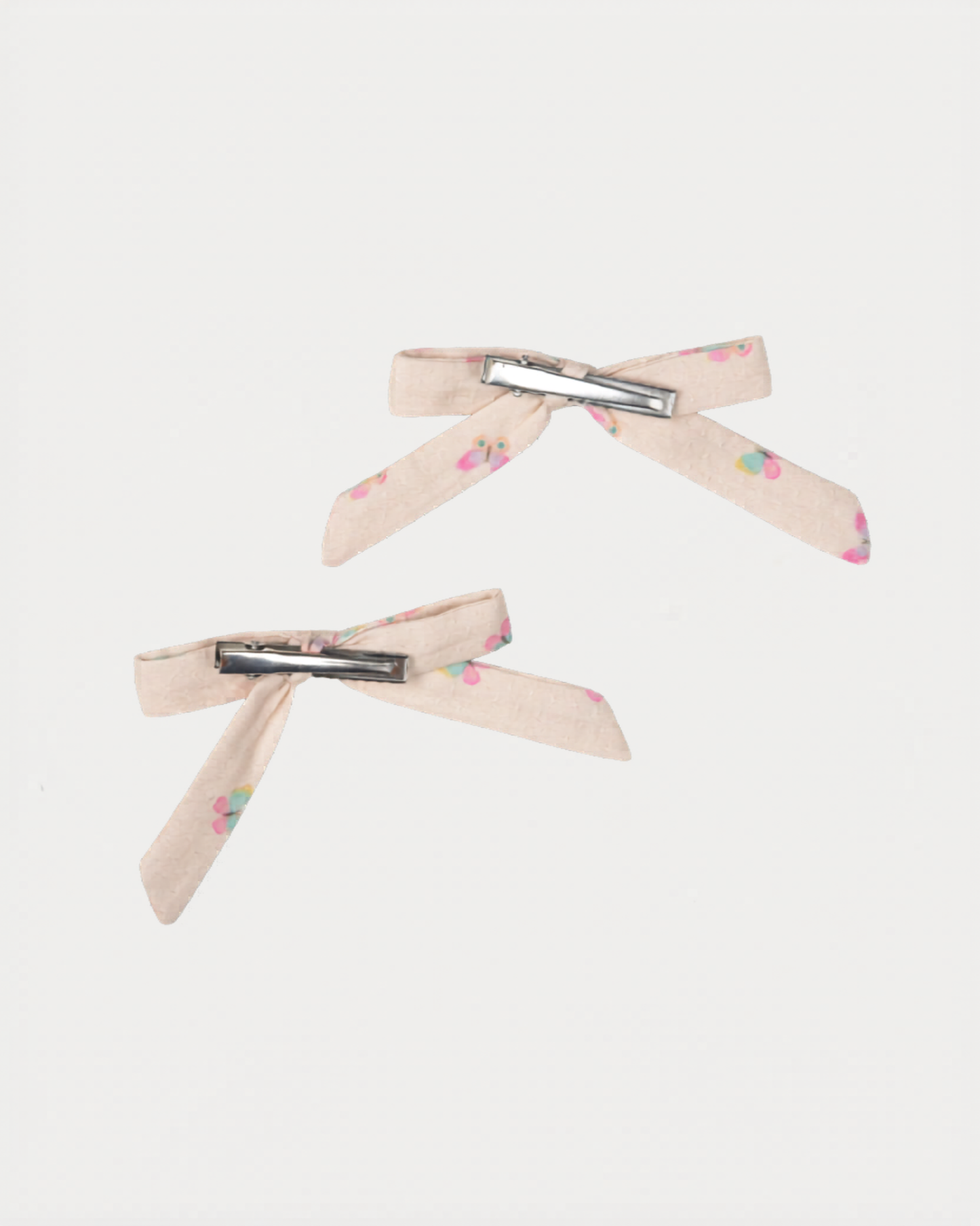 Early Sunday, Grace Clip in Butterflies print, made from Printed Cotton Tiny Swiss Dobby fabric, featuring a set of two bow clips with a secure fit, shown in a back flat-lay view