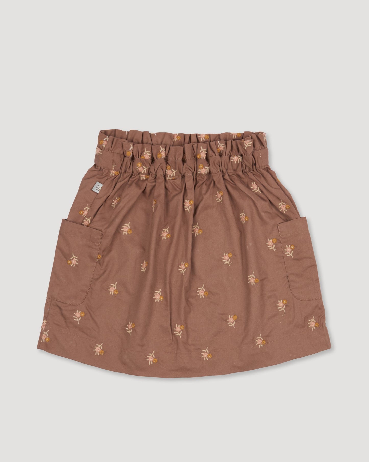 Early Sunday, Hilda Skirt in Bark, made from All-over embroidered 30s cotton brushed twill fabric, featuring A-line shape with a gathered elastic waistband for comfort, shown in a back flat-lay view