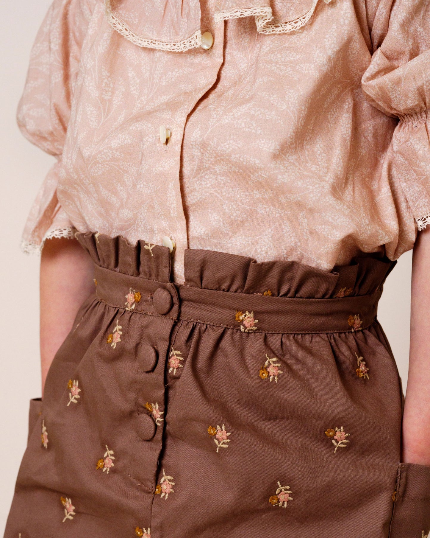 Early Sunday, Hilda Skirt in Bark, made from All-over embroidered 30s cotton brushed twill fabric, featuring A-line shape with a gathered elastic waistband for comfort, shown in a front view of model wearing it