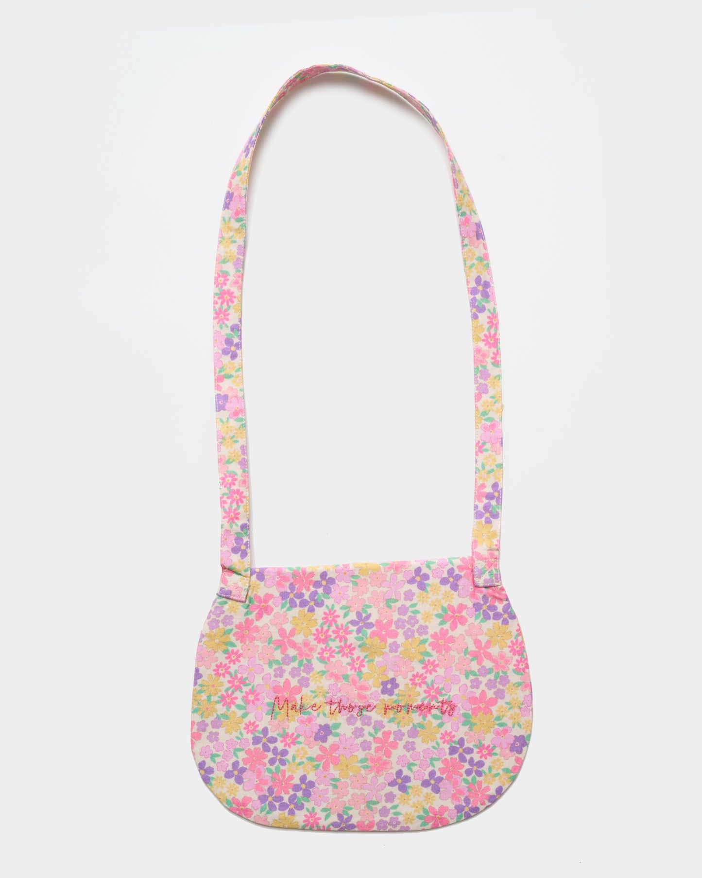 Early Sunday, Hudson Purse in Emma Floral Purple color, made from Organic Printed Cotton Cambric fabric, featuring a gathered sling purse design with a flap closure, shown in back flat-lay view